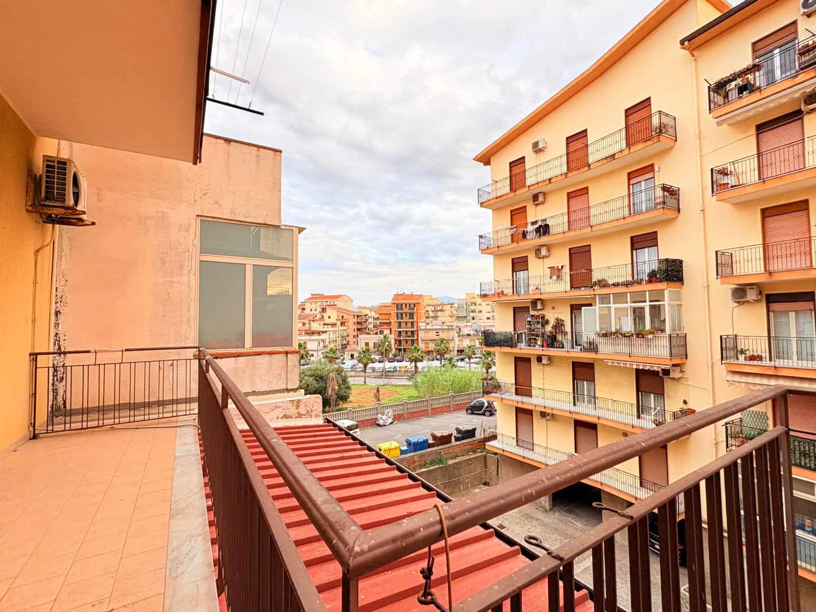 Appartamento con balcone in un complesso residenziale a città, vista su edifici e spazi verdi, ideale per vivere in zona urbana con comfort e accesso a servizi.