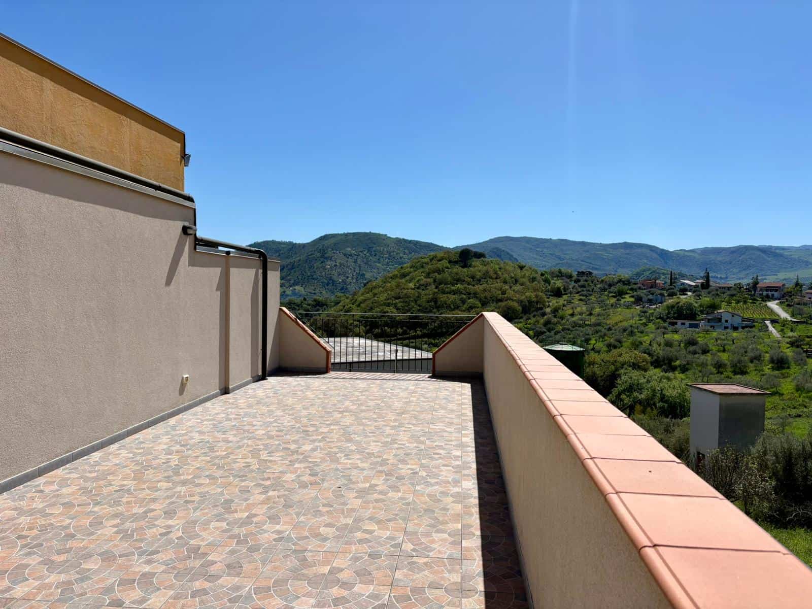 Ampio terrazzo con vista panoramica sulle colline verdi e il cielo azzurro, ideale per relax e momenti all'aperto.