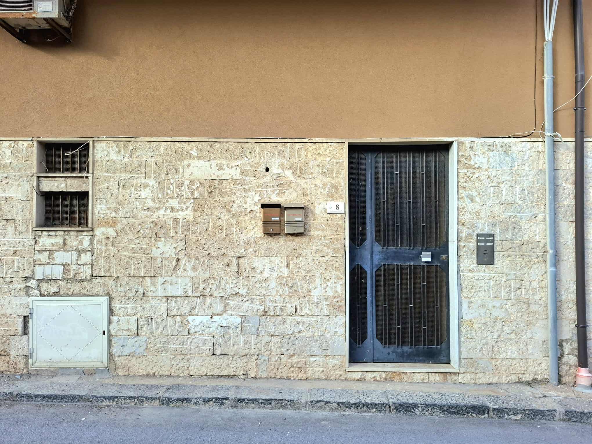 Porte d'ingresso in stile rustico con pareti in pietra e dettagli moderni, situata in un edificio storico a città.