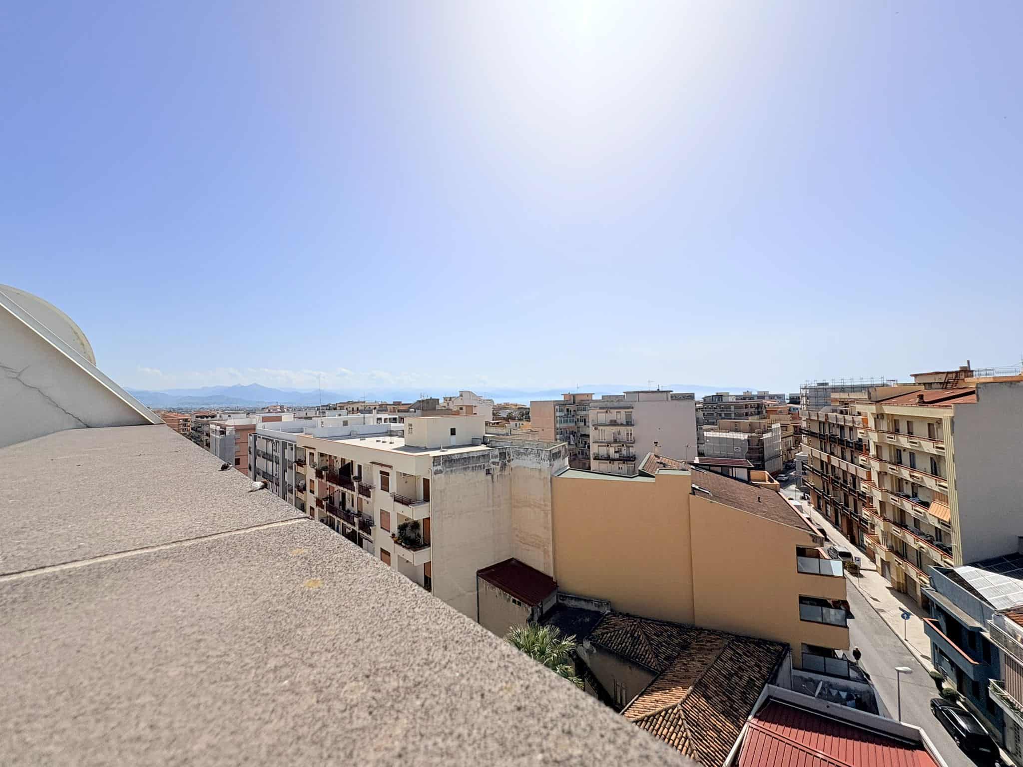 Vista panoramica di un quartiere urbano con edifici residenziali e strade, sotto un cielo sereno e soleggiato, ideale per immobili in vendita o affitto a NextCasa.