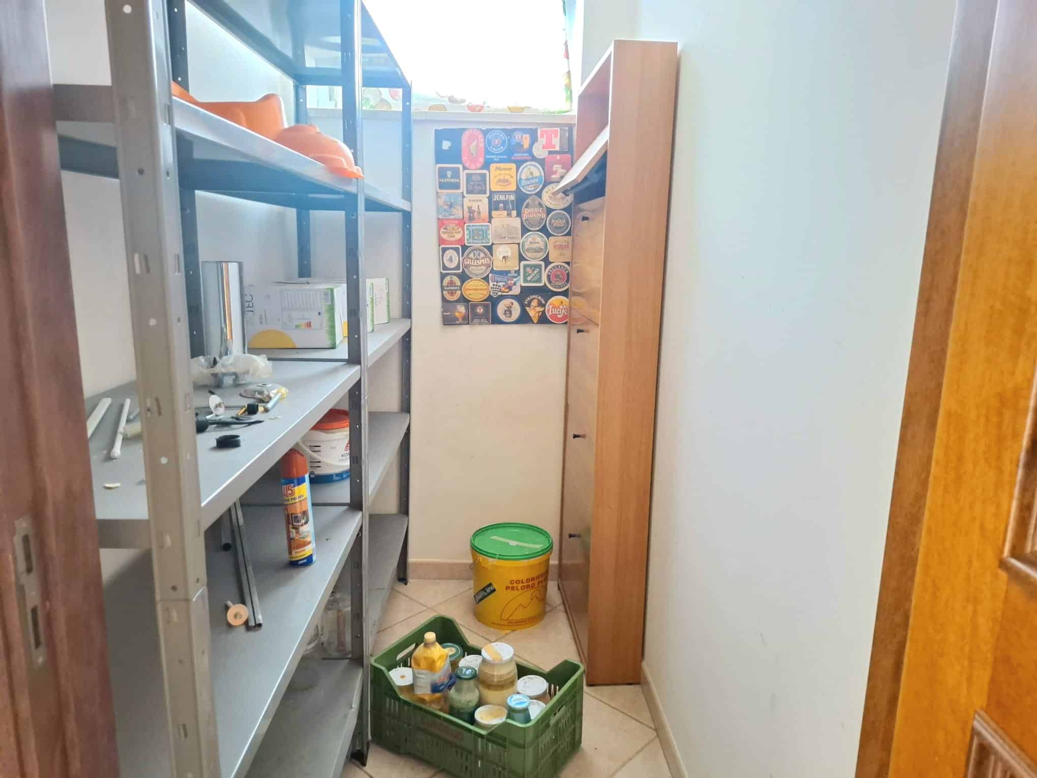 Lavanderia con scaffali e contenitori per detersivi, spazio compatto e funzionale, ideale per organizzare prodotti per la pulizia e accessori domestici.