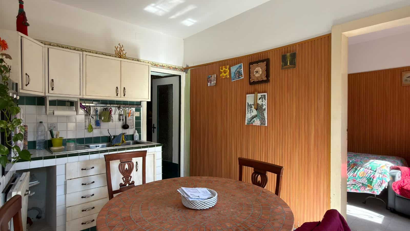 Cucina abitabile con mobili classici, pareti in legno e zona pranzo centrale, ambiente accogliente e funzionale in un appartamento NextCasa in Italia.