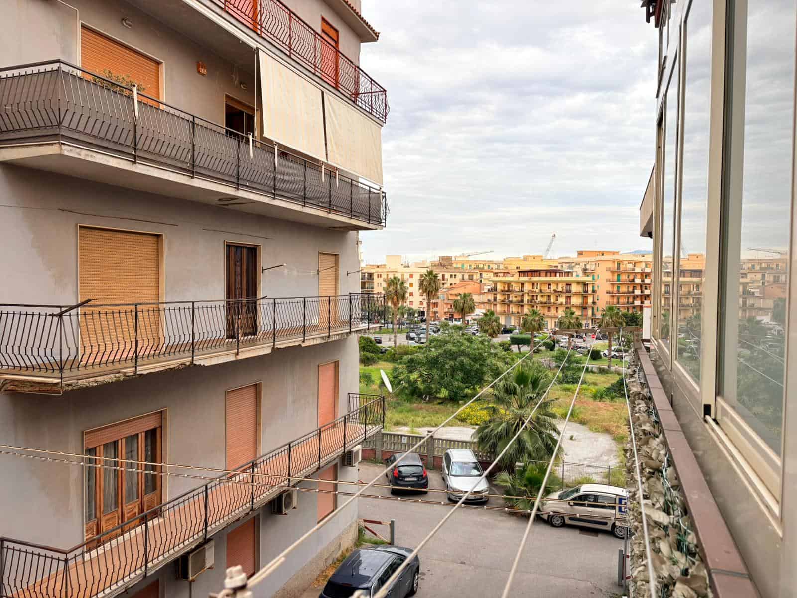 Appartamento con balcone panoramico in zona residenziale, vista su giardini e complessi abitativi moderni, ideale per vivere in tranquillità vicino ai servizi cittadini.