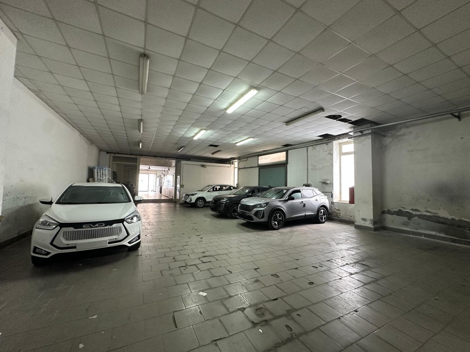 Auto in vendita in un garage coperto, spazio ampio e ben illuminato, ideale per parcheggio e deposito veicoli, con pareti e pavimenti in buone condizioni, ambiente sicuro e protetto.