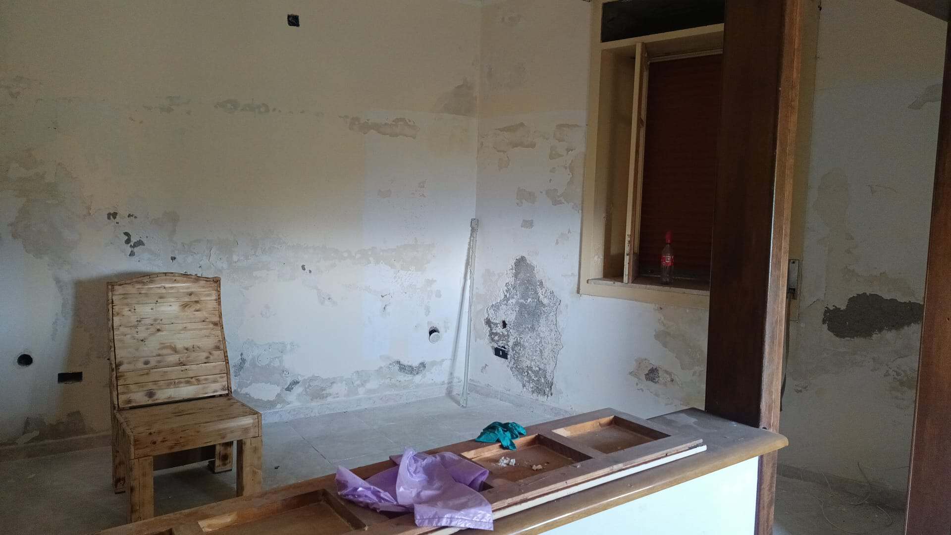 Porte in legno e pareti in fase di ristrutturazione, ambiente interno con mobili in legno e lavori di ristrutturazione in corso, spazio abitativo in fase di rinnovamento, immobile in fase di ristruttu.