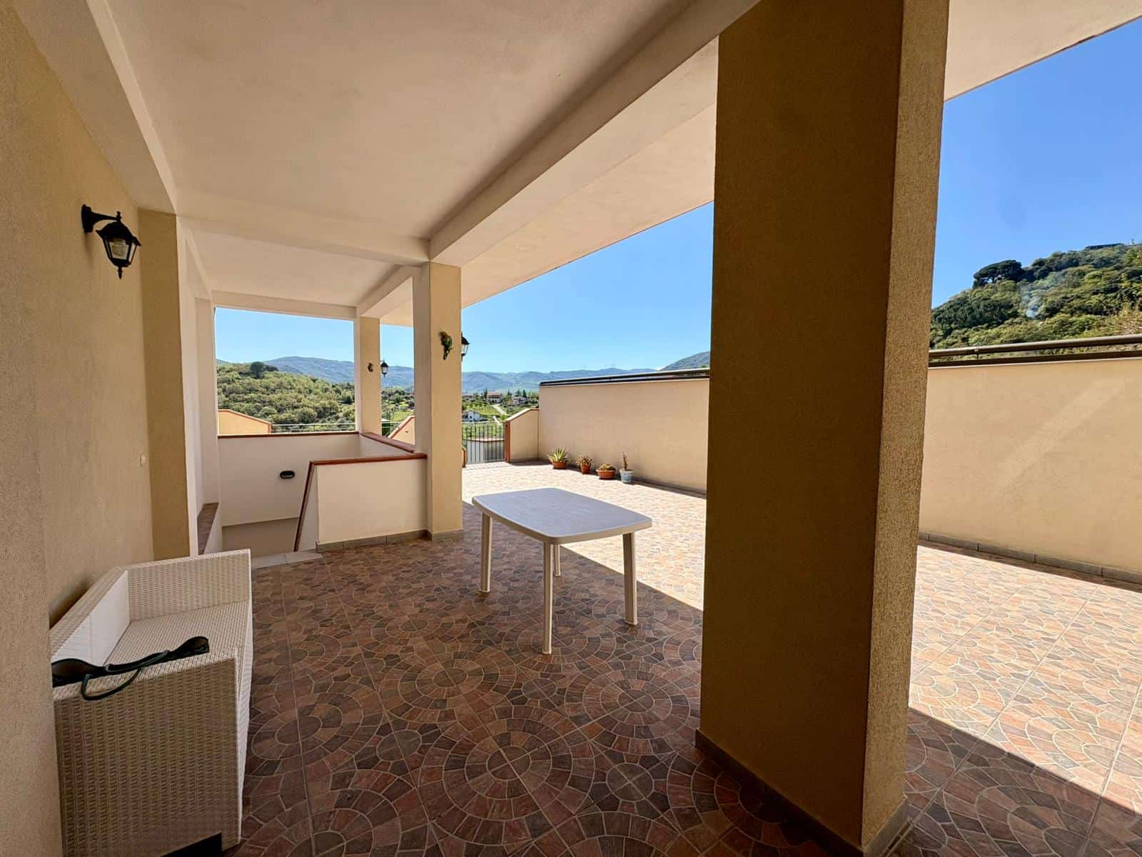 Ampia terrazza con vista panoramica, ideale per relax e momenti all'aperto, con pavimentazione in pietra e arredi confortevoli, perfetta per vivere all'aperto in un ambiente tranquillo e luminoso.