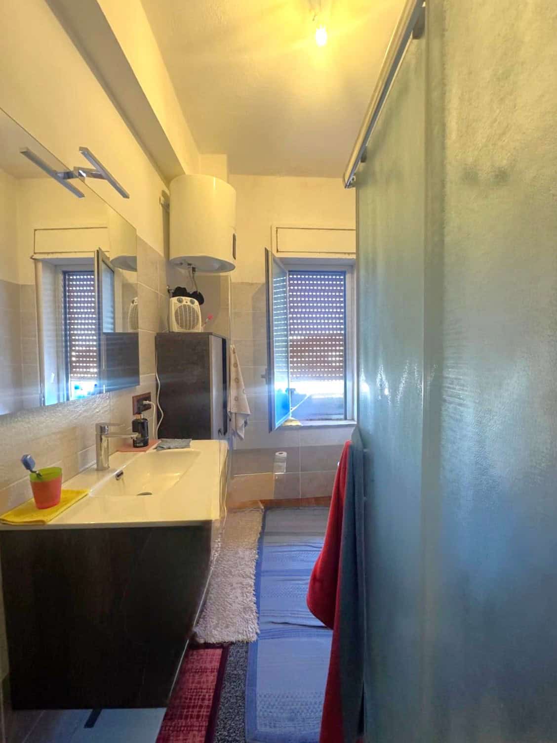 Lavabo e finestra in un bagno di casa, con arredi moderni e dettagli funzionali, ideale per chi cerca soluzioni di design e comfort.