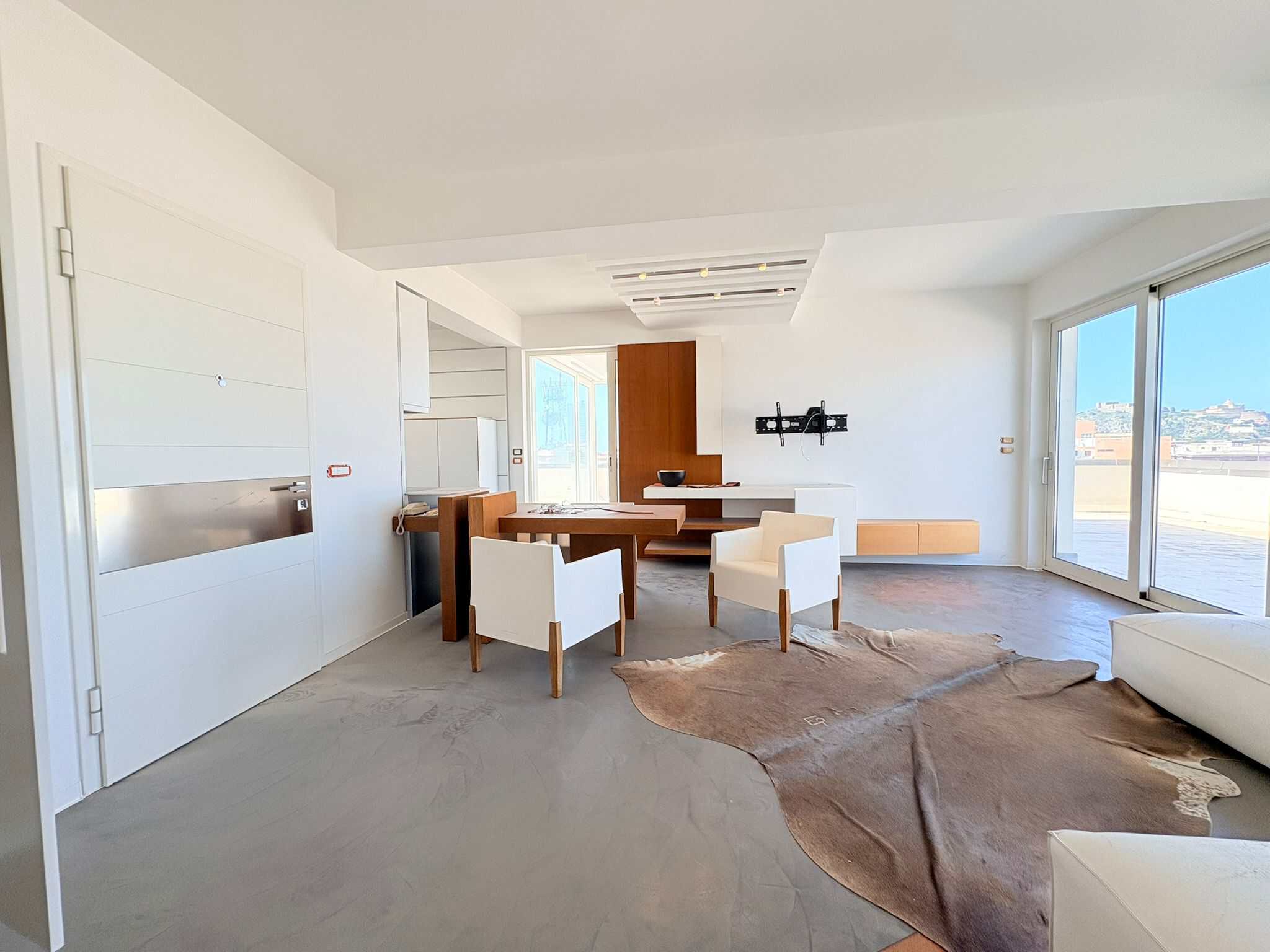 Moderno soggiorno con grandi finestre, arredi eleganti e pavimento in cemento, ideale per vivere in comfort e stile.