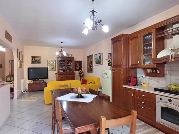 Ampia cucina e zona living con arredi eleganti, mobili in legno e dettagli decorativi, ideale per vivere confortevoli momenti in casa. Perfetta per chi cerca soluzioni abitative funzionali e di stile.