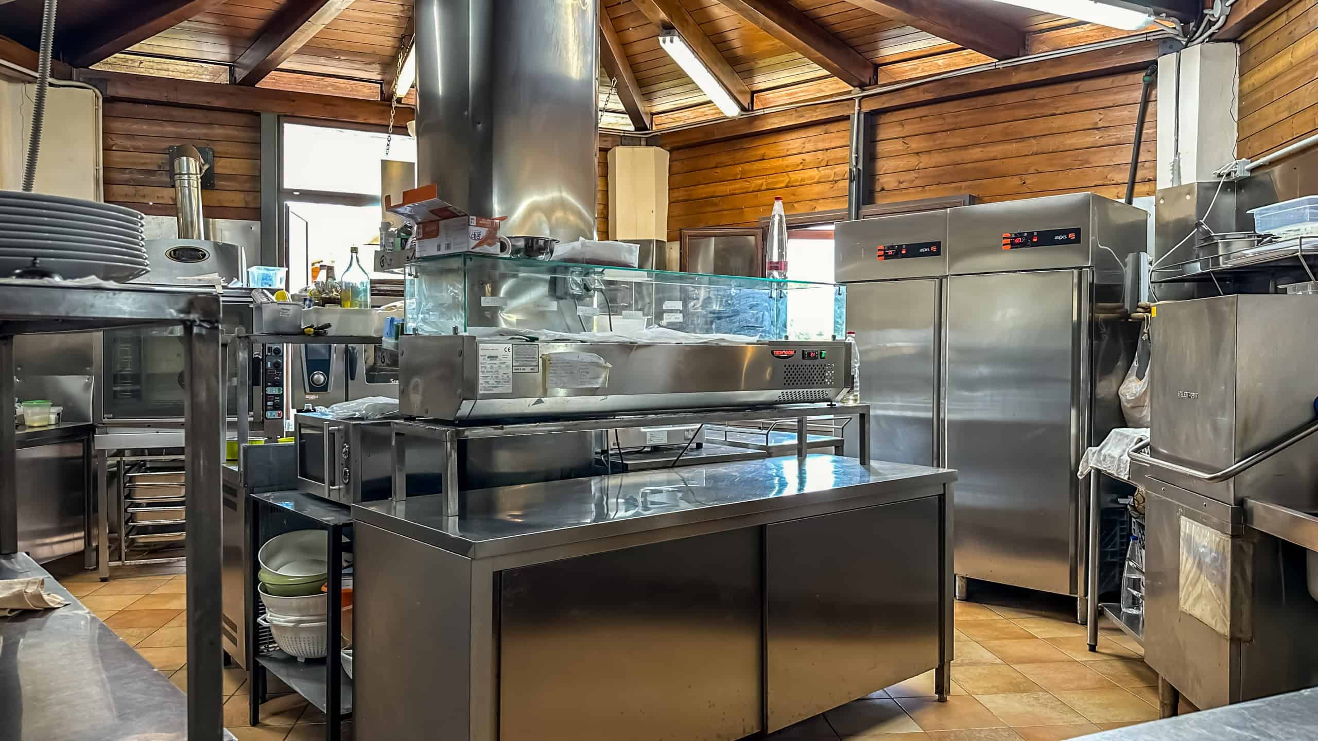 L'immagine mostra una cucina professionale con attrezzature da ristorazione in acciaio inox, ideale per ristoranti o cucine commerciali.