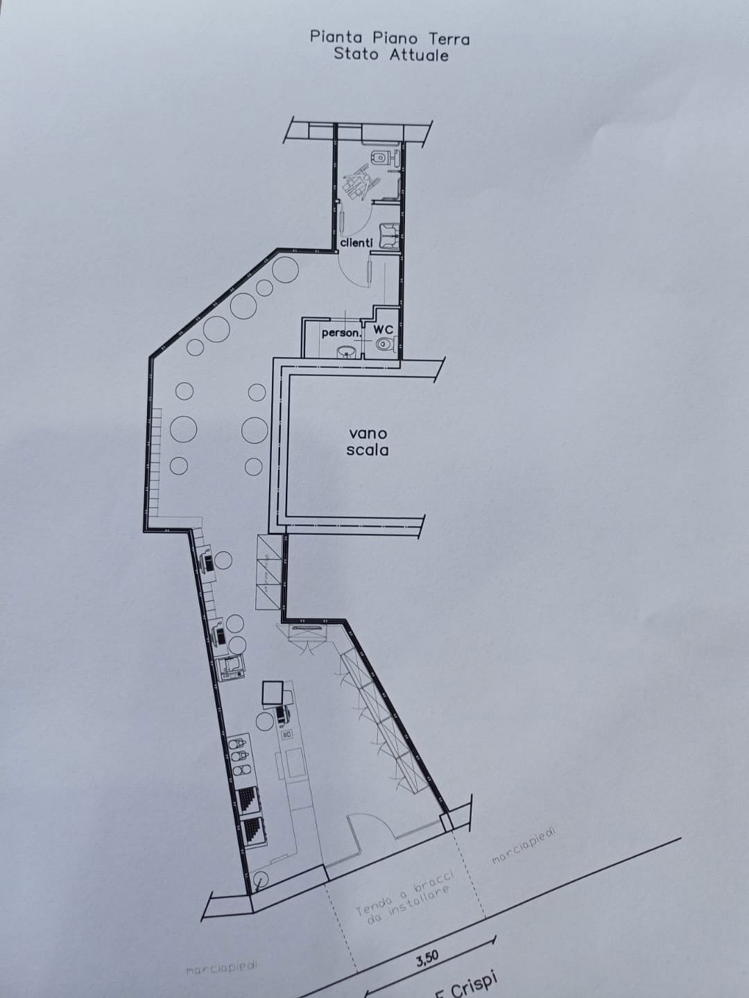 Il piano terra di un edificio con dettagli di layout, inclusi spazi per clienti e personale, servizi igienici e una scala, rappresentato in un disegno tecnico.