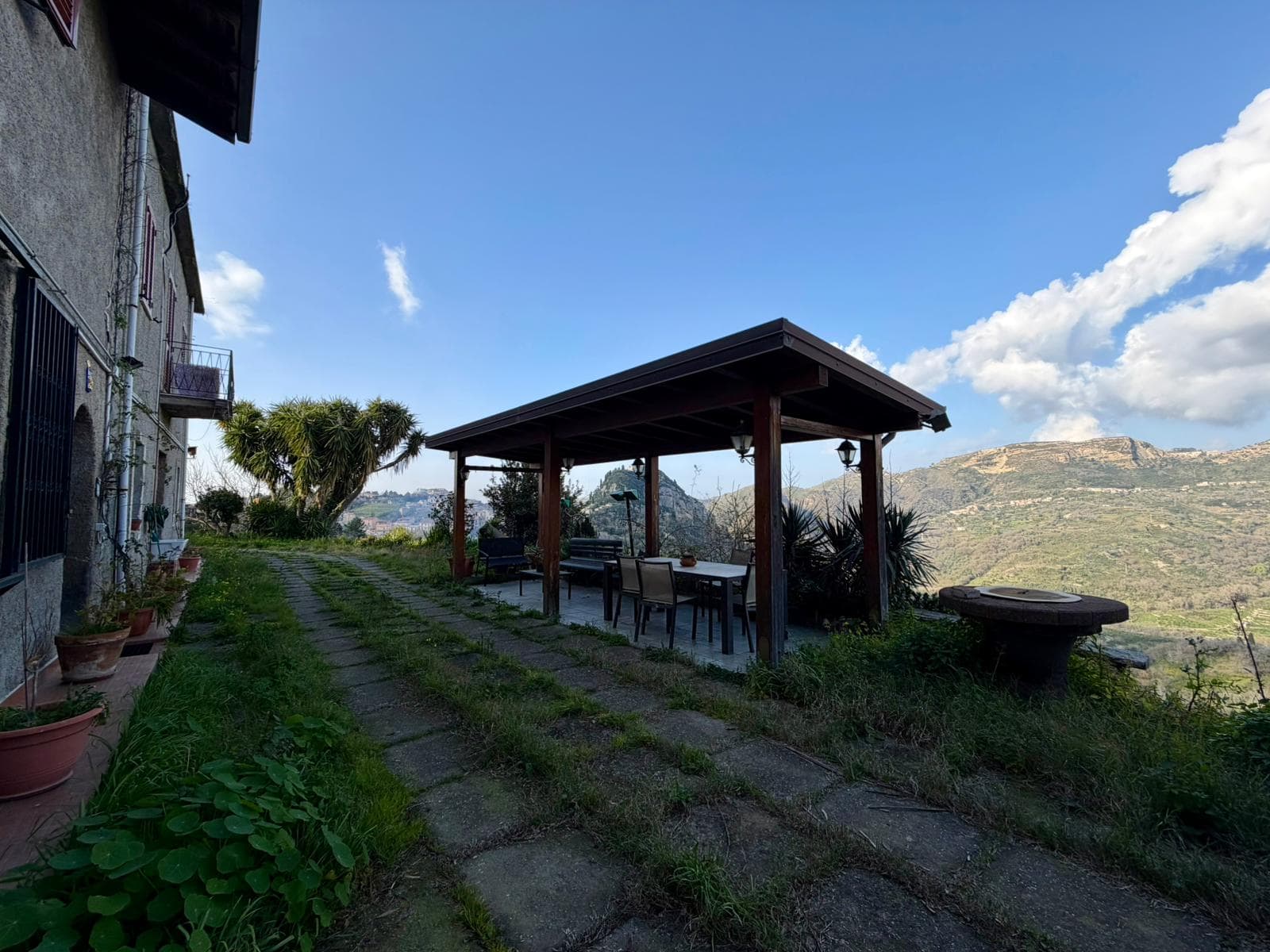 Panchina e area relax all'aperto con vista panoramica sulle colline toscane, ideale per momenti di relax e convivialità in un ambiente naturale e tranquillo.