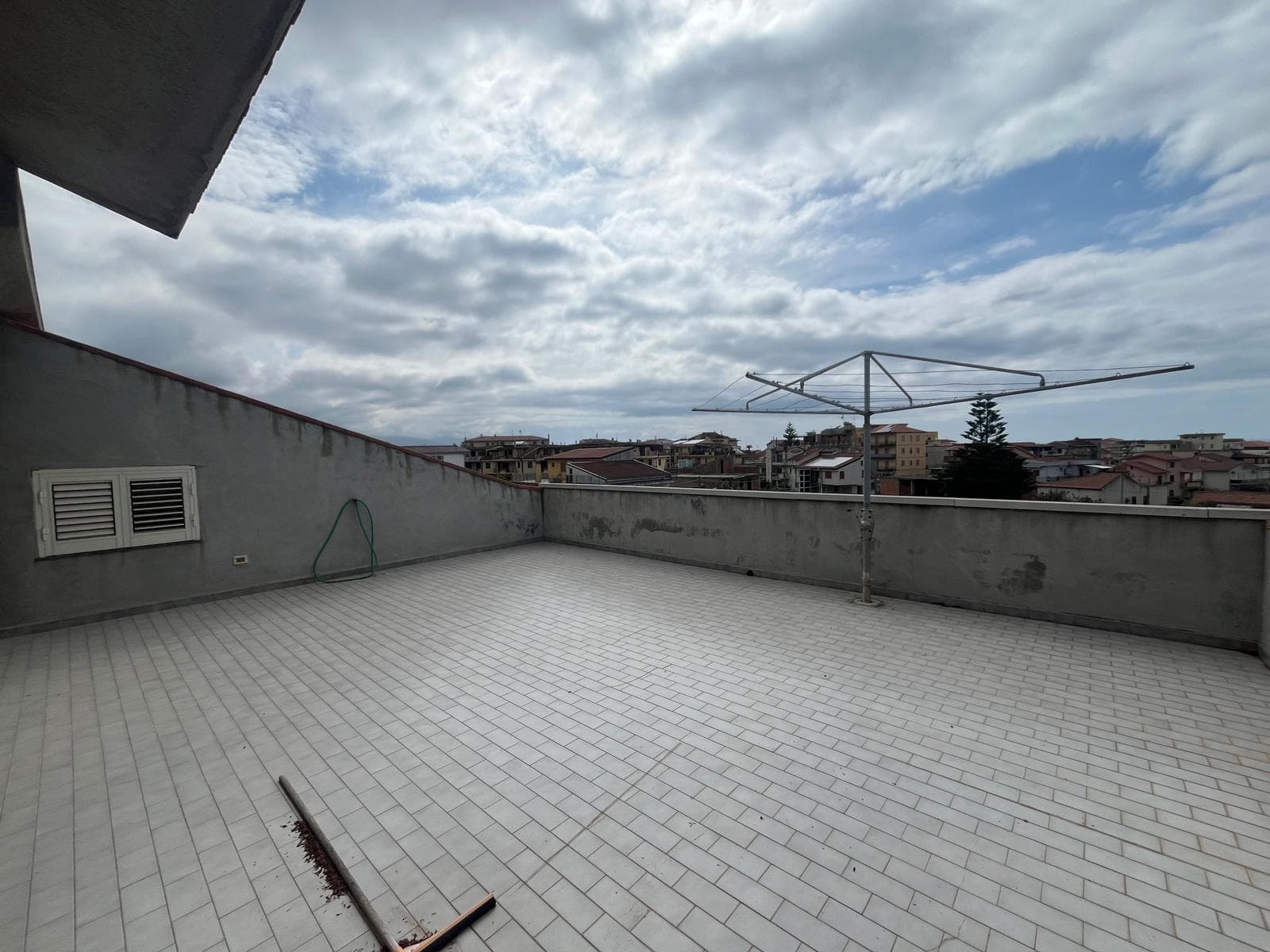Terrazza panoramica con vista sulla città e cielo nuvoloso, ideale per relax e socializzare all'aperto.