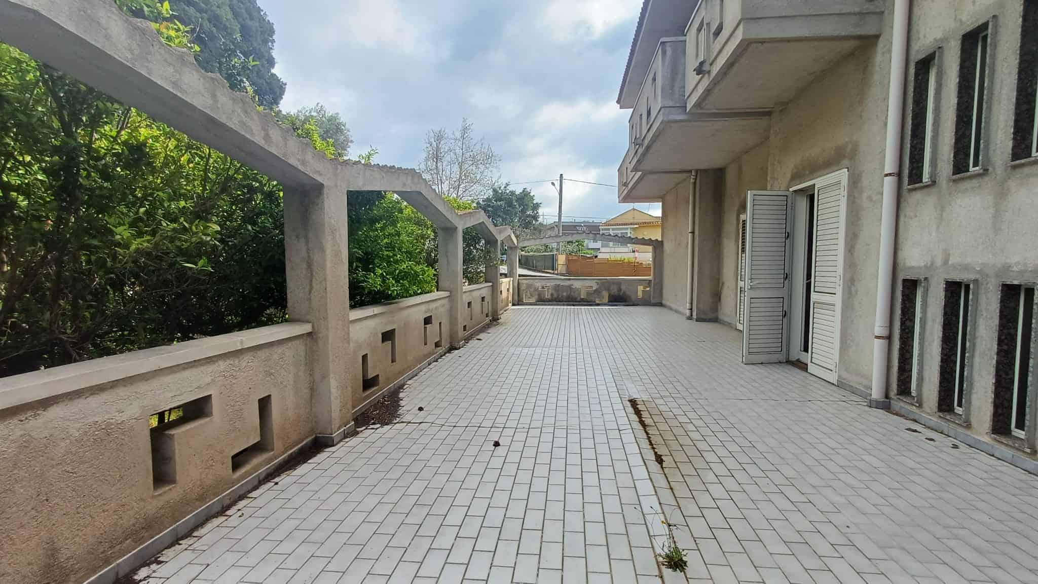 Ampio terrazzo esterno con vista sul verde, ideale per relax e socializzazione, in un complesso residenziale moderno vicino a servizi e natura.