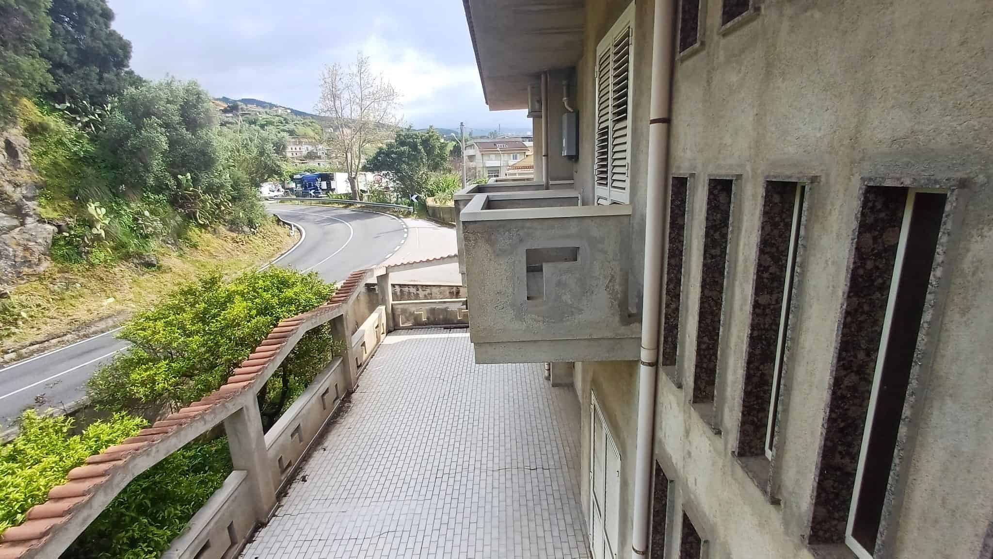 Elegante balcone di un appartamento con vista sulla strada e sul paesaggio circostante, ideale per relax e momenti all'aperto.