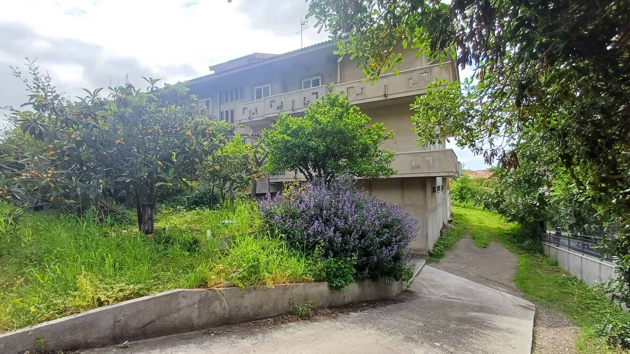 Ampia vista di un complesso residenziale immerso nel verde con giardini curati e percorsi pedonali, ideale per chi cerca tranquillità e natura vicino alla città.