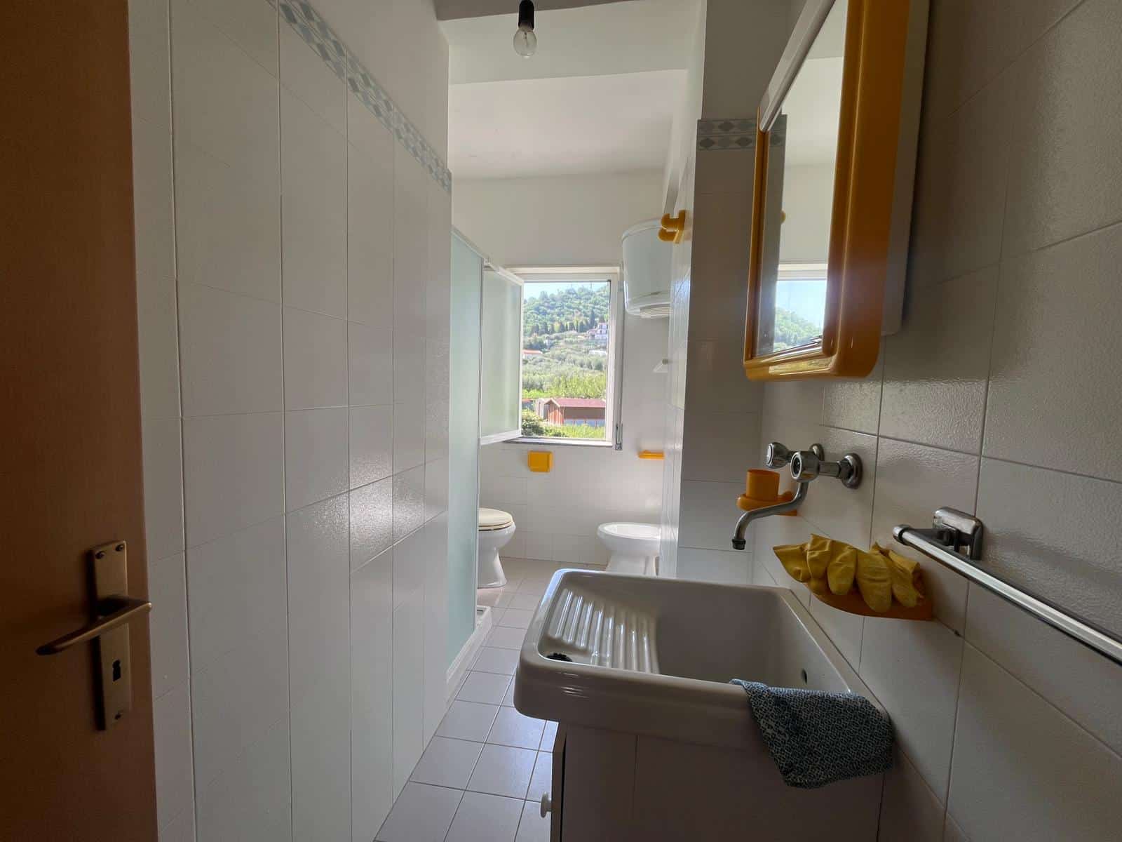 Lavabo e bagno luminoso con vista panoramica, arredamento funzionale e accessori moderni, ideale per ambienti di comfort e praticità.