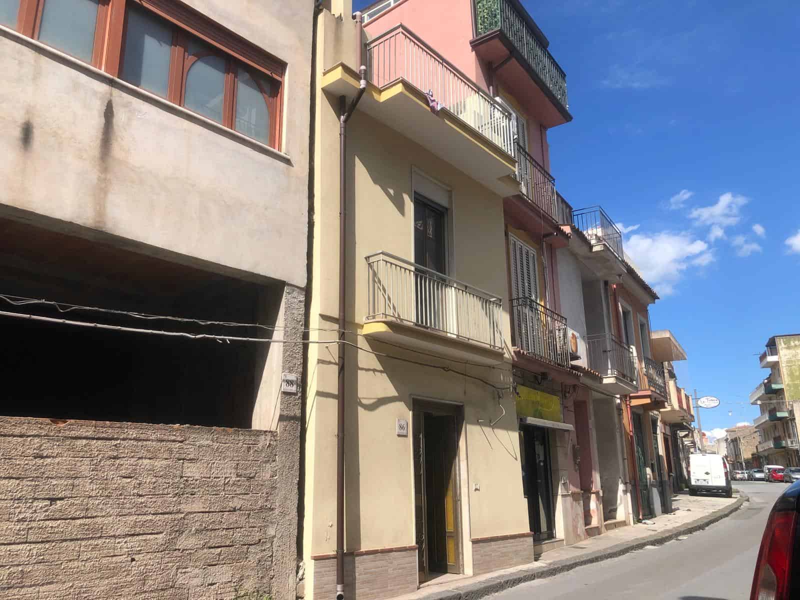 Appartamento in centro città con balcone e facciata colorata, situato in zona residenziale vicino a negozi e servizi, ideale per vivere in un quartiere vivace e ben collegato.