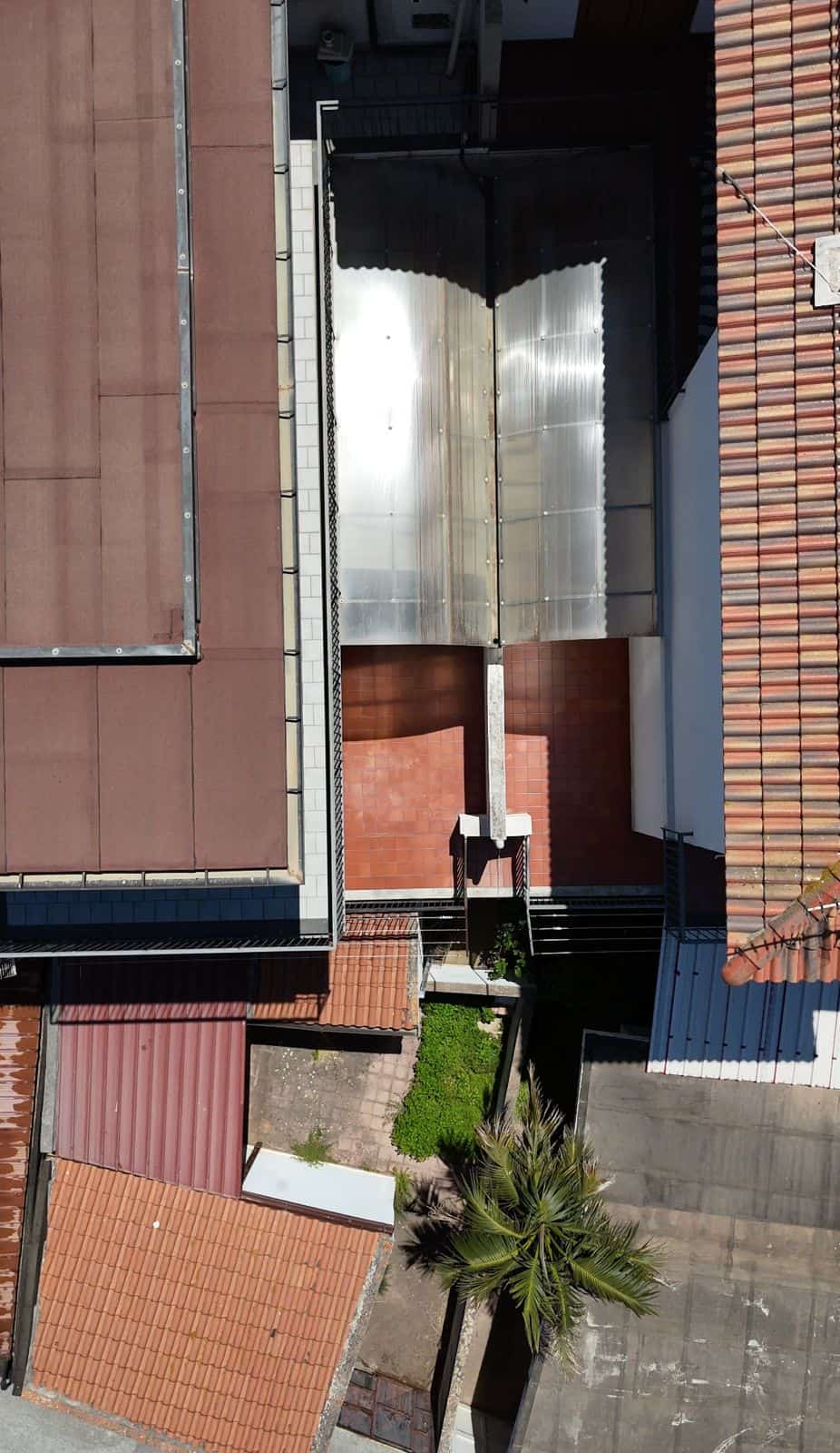Il cancello automatico in metallo e vetro installato tra edifici residenziali, vista dall'alto.