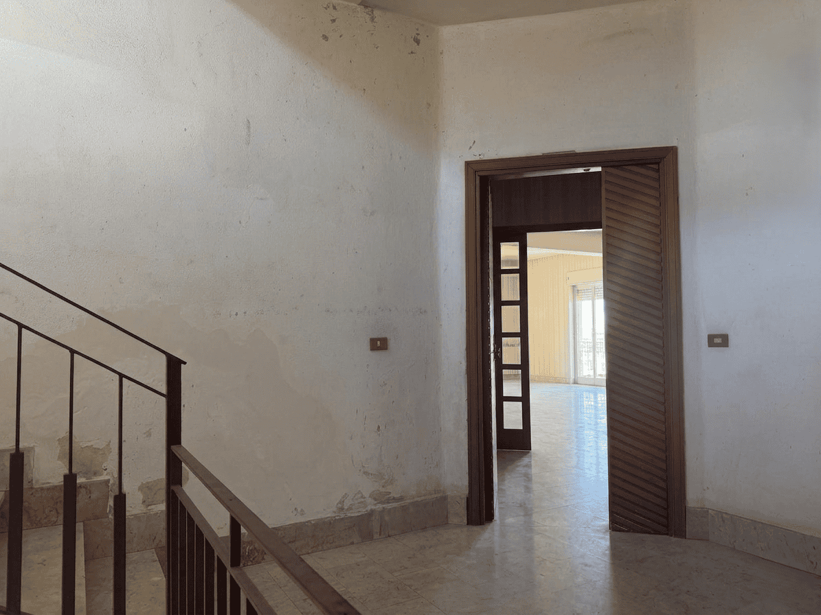 Immagine di un ingresso di casa con scala interna e porta in legno, ambienti luminosi e spaziosi, ideale per residenze moderne e confortevoli.
