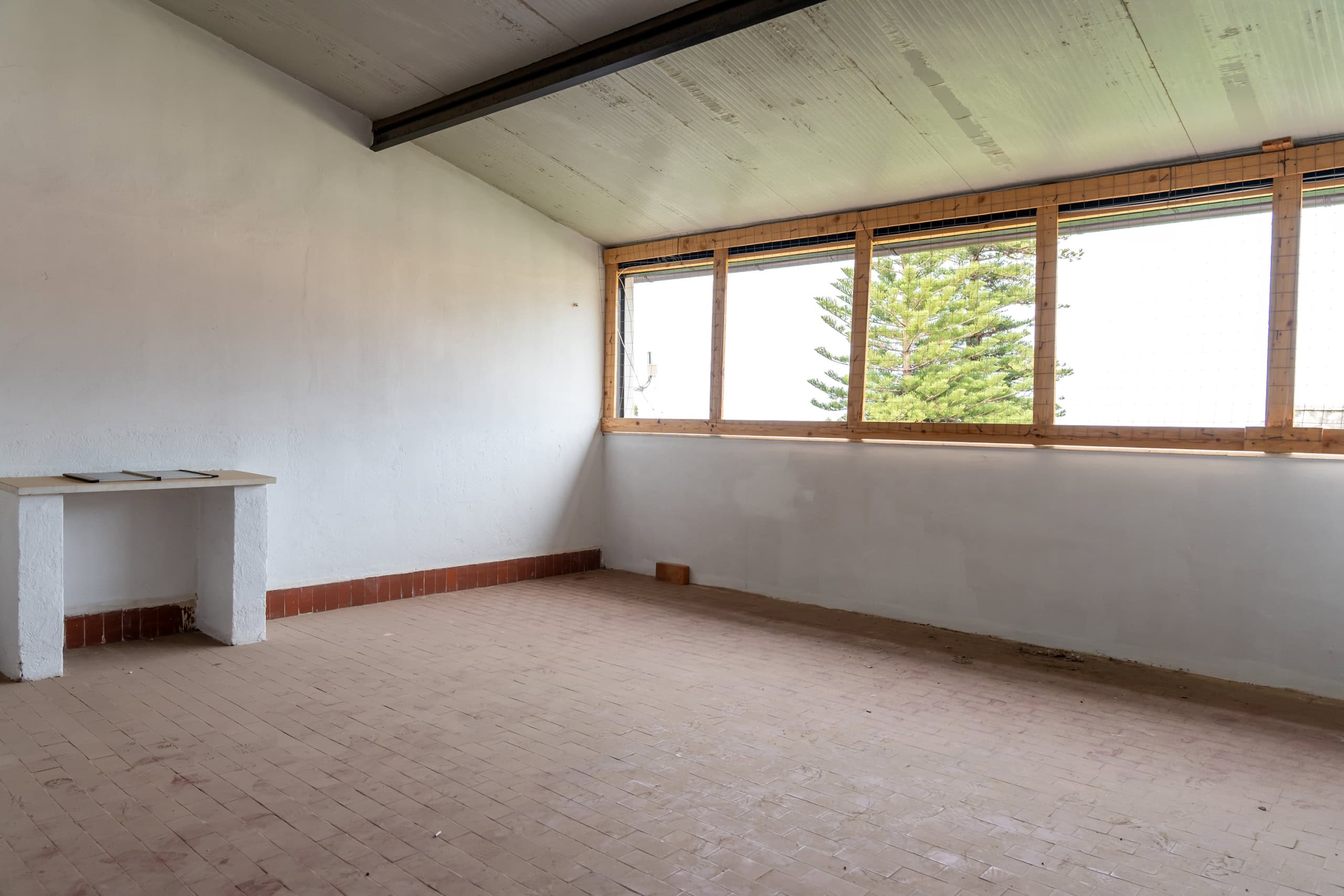 Aggiunta di un'immagine di un interno di un appartamento in fase di ristrutturazione, con grandi finestre e vista sulla natura.