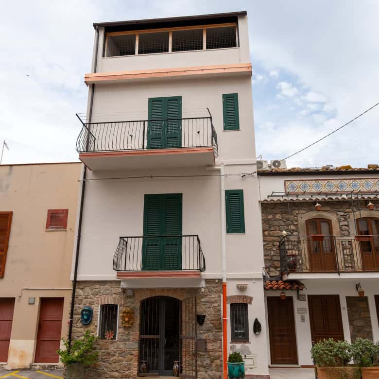 Edificio residenziale moderno con balconi e facciata bianca, situato in zona urbana di NextCasa, ideale per investimenti immobiliari e affitti turistici in Italia.