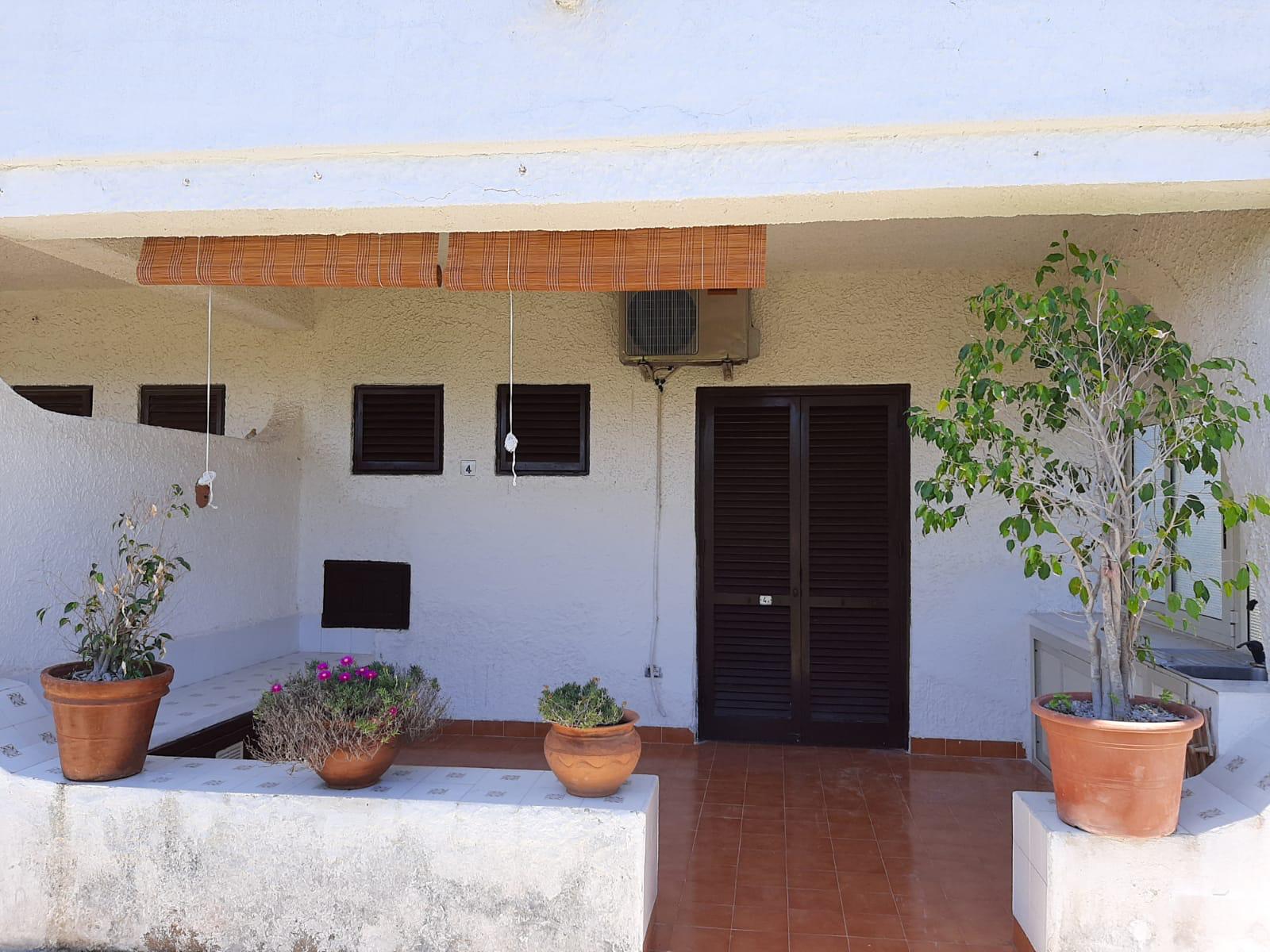Ampia terrazza esterna con piante in vaso, ideale per relax e convivialità, con accesso a una casa moderna e luminosa. Spazio esterno ben curato, perfetto per vivere momenti all'aperto in un ambiente.