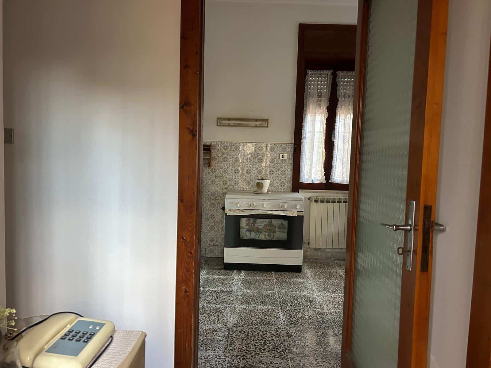 Cucina piccola e funzionale con forno, lavabo e finestra, in un appartamento in stile classico.