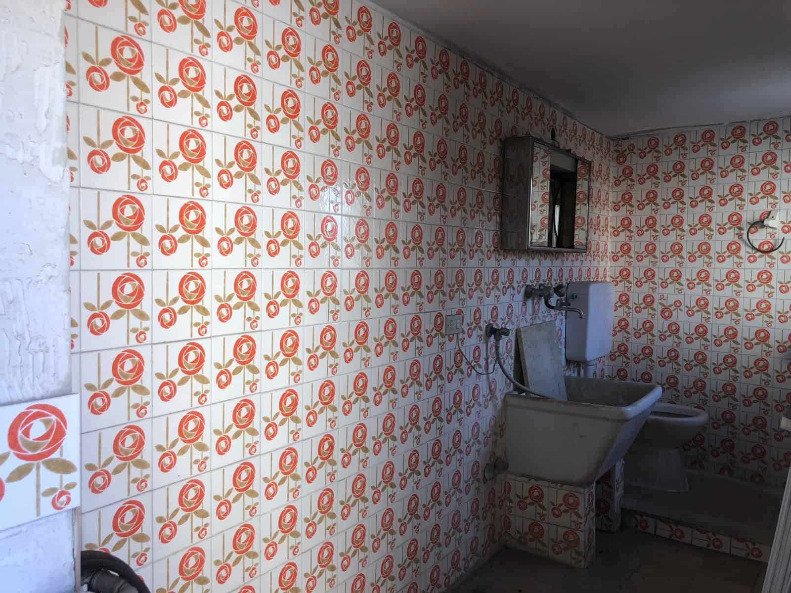 Piastrelle decorative in ceramica con motivo floreale rosso e bianco, ideale per rivestimenti di cucine e bagni moderni e colorati.