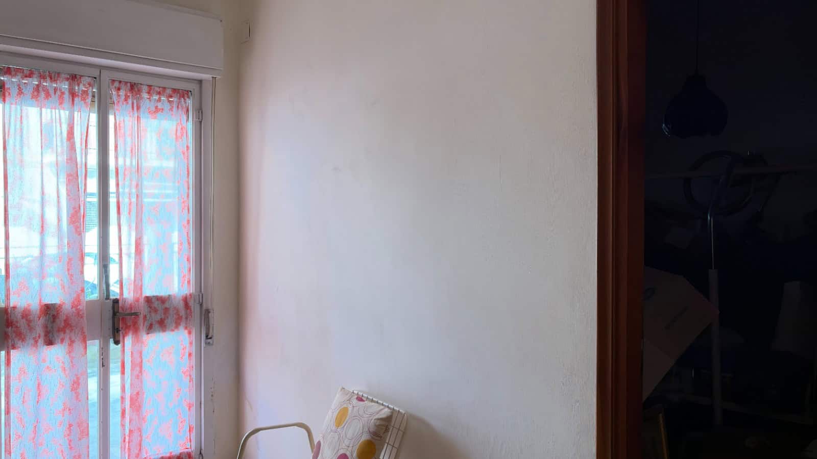 Ampia finestra con tende leggere in una stanza luminosa, ideale per ambienti residenziali moderni e confortevoli.