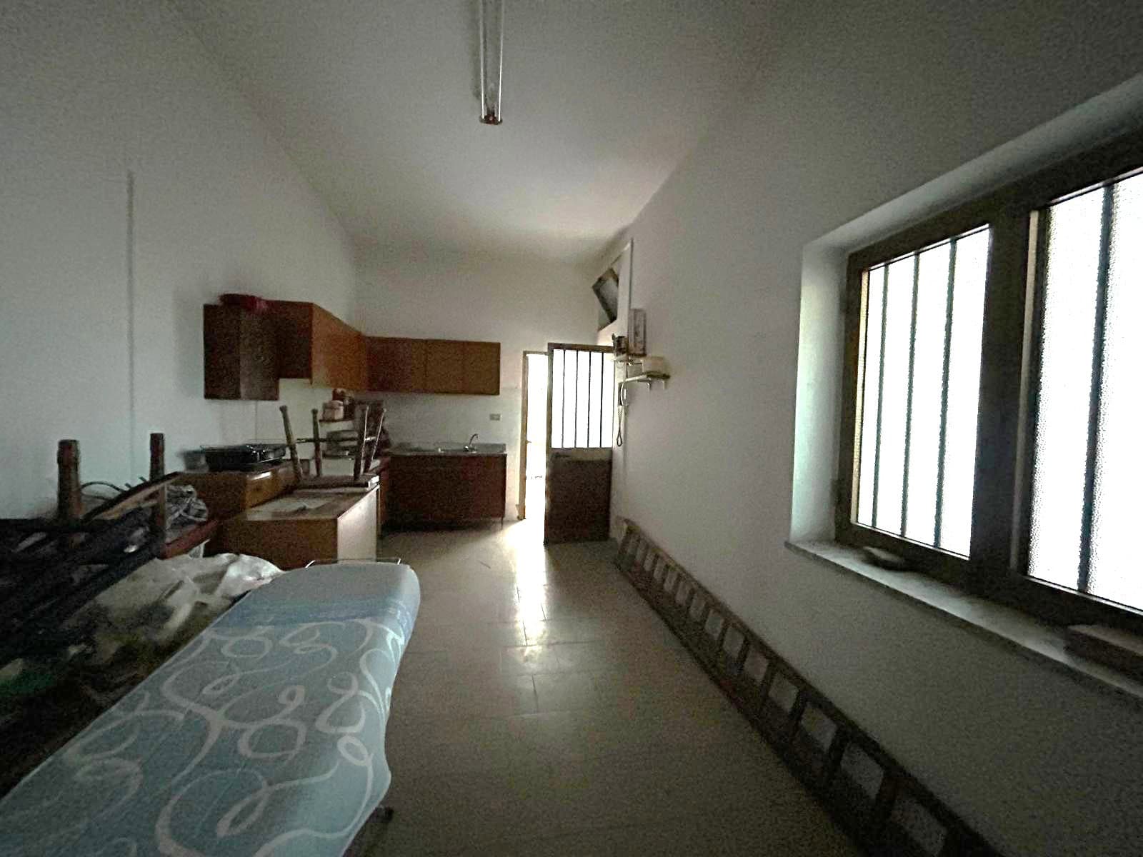 Pannello solare installato sul tetto di una casa, vista dall'interno con pareti bianche e finestra con grate di sicurezza, ambiente luminoso e spazioso.