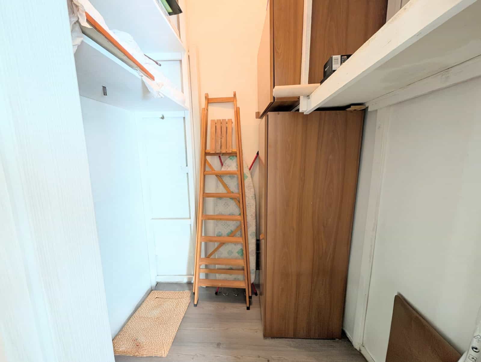 Ripetitore di scale in legno in un ambiente domestico, tra mobili e pareti bianche, con pavimento in legno chiaro, ideale per ottimizzare gli spazi e migliorare la funzionalità della casa.