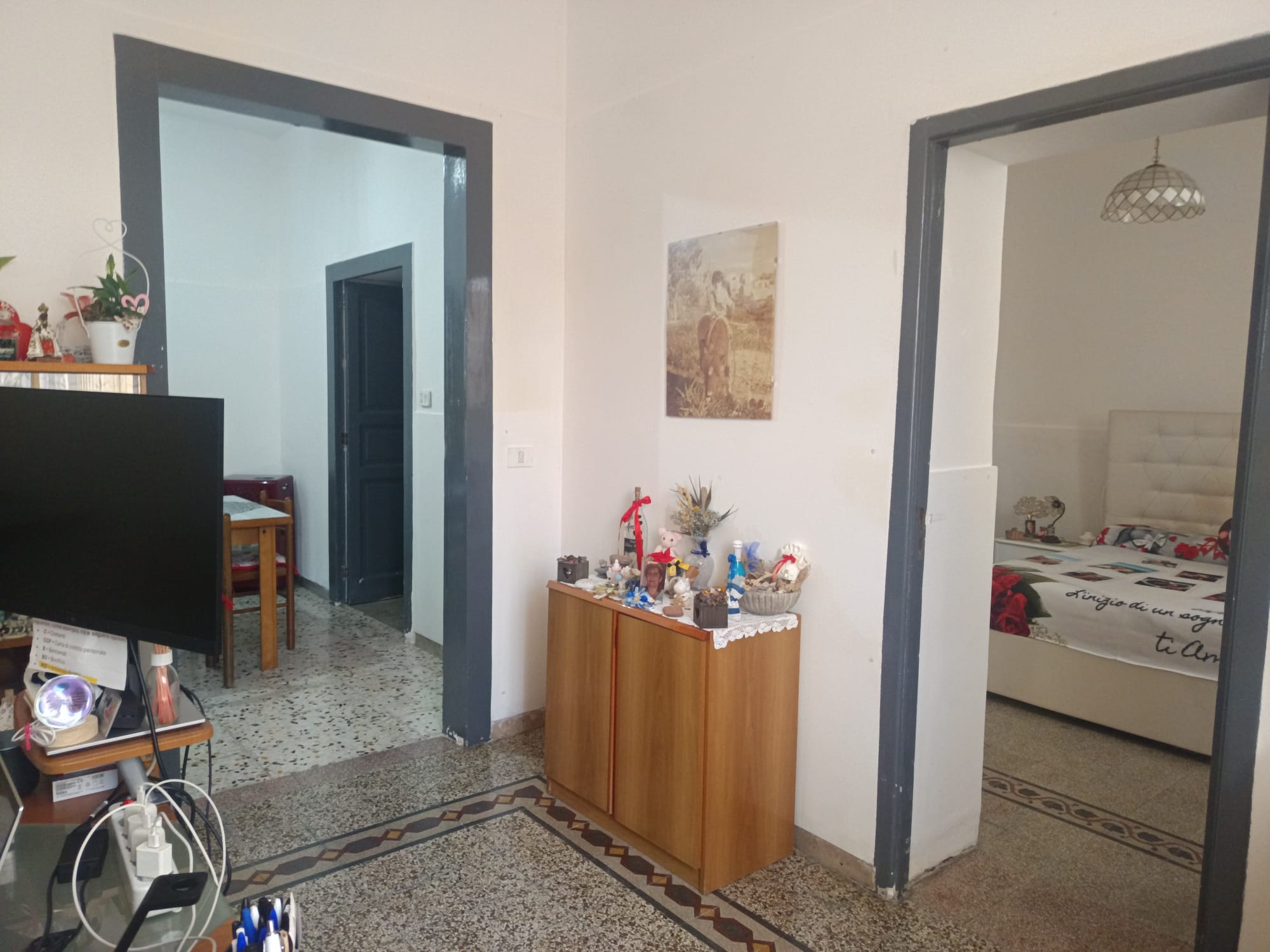 Ampia vista di un ingresso di casa con corridoio e camera da letto, arredamento semplice e decorazioni natalizie, ambienti luminosi e accoglienti, ideale per chi cerca soluzioni di affitto o vendita i.