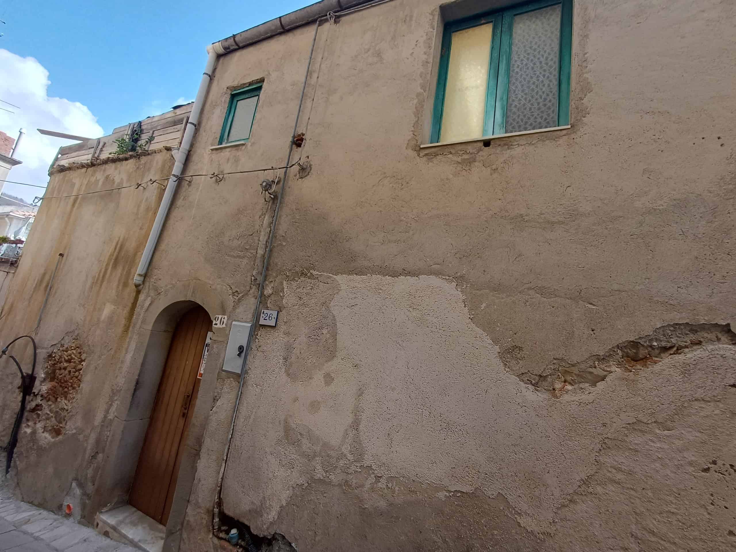 Edificio storico con pareti in pietra e finestre moderne, situato in un quartiere residenziale.