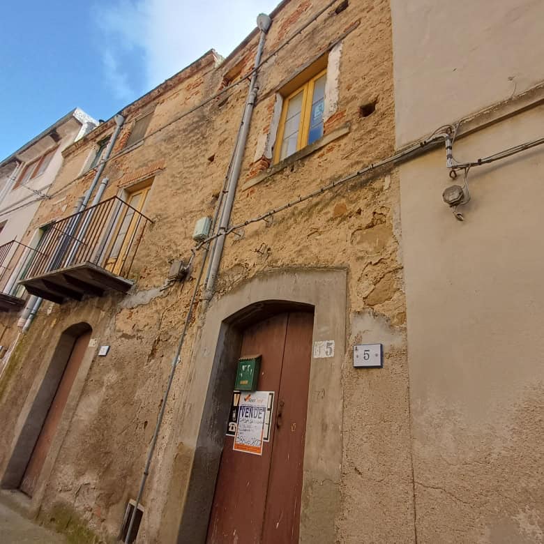 Casa storica in centro storico con facciata in pietra e porta in legno, situata in una via pittoresca. Perfetta per chi cerca un'abitazione con charme e carattere autentico.