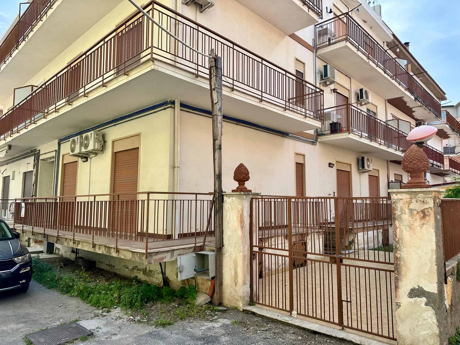 Edificio residenziale con balconi e recinzione in ferro battuto, vista esterna di un appartamento in zona urbana.
