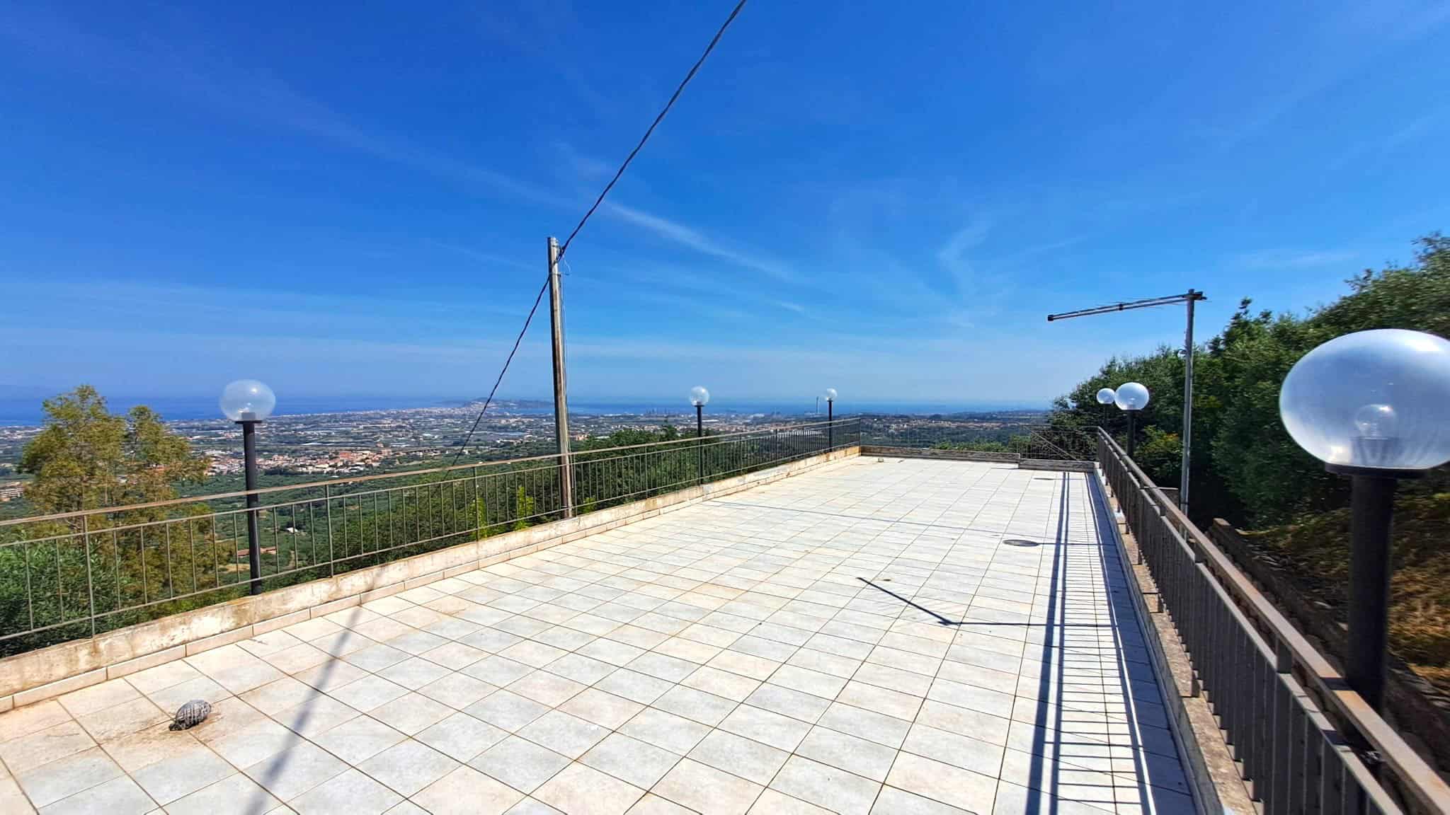 Ampia terrazza panoramica con vista sulla città e sul paesaggio circostante, illuminata da lampioni eleganti e dotata di rete di sicurezza. Ideale per momenti di relax e socializzazione all'aperto.