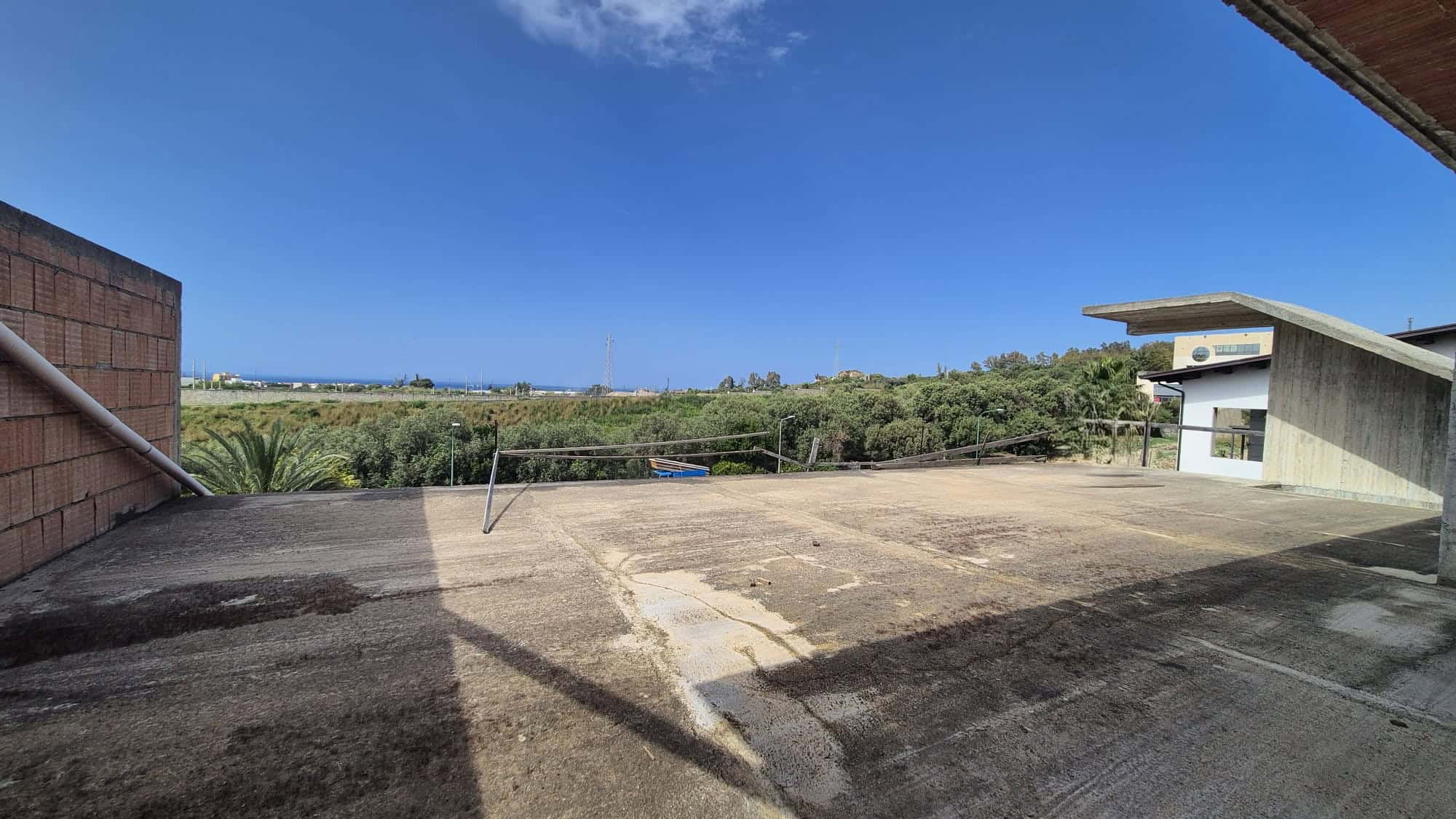 Ampio terrazzo all'aperto con vista panoramica su paesaggio verde e cielo sereno, ideale per relax e attività all'aperto, in un contesto residenziale moderno.