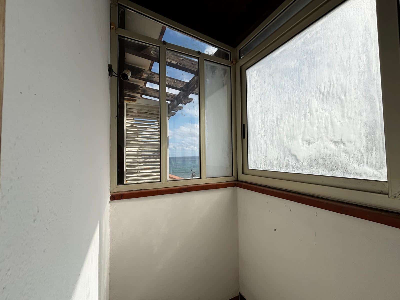 Ampio balcone con vista mare, infissi in alluminio e vetri panoramici, ideale per relax e godersi il paesaggio marino, in un appartamento in vendita o in affitto a NextCasa.