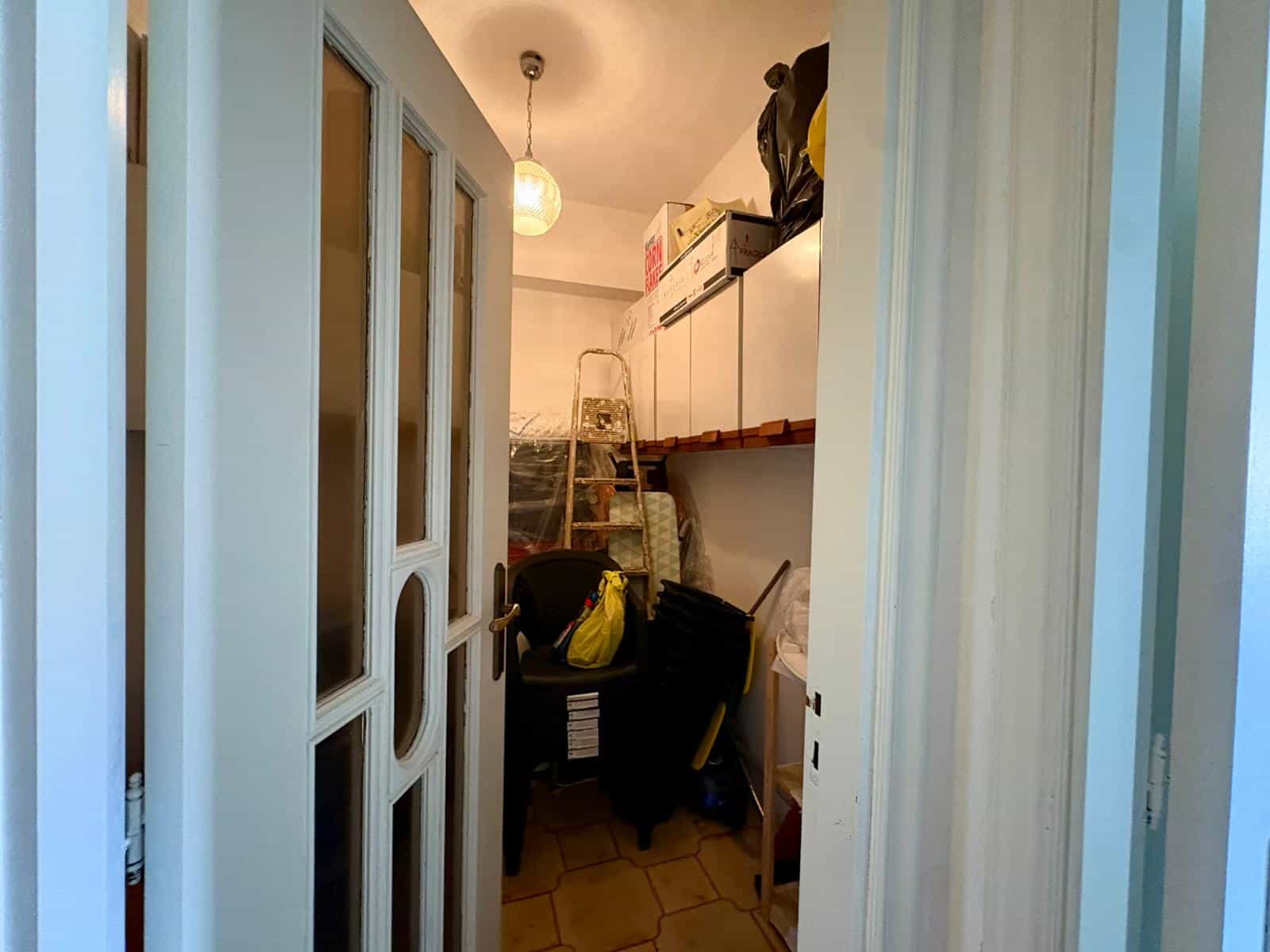Spazio di stoccaggio in un ripostiglio domestico con scaffali, scatole e attrezzi, ideale per organizzare oggetti e utensili in modo efficiente.