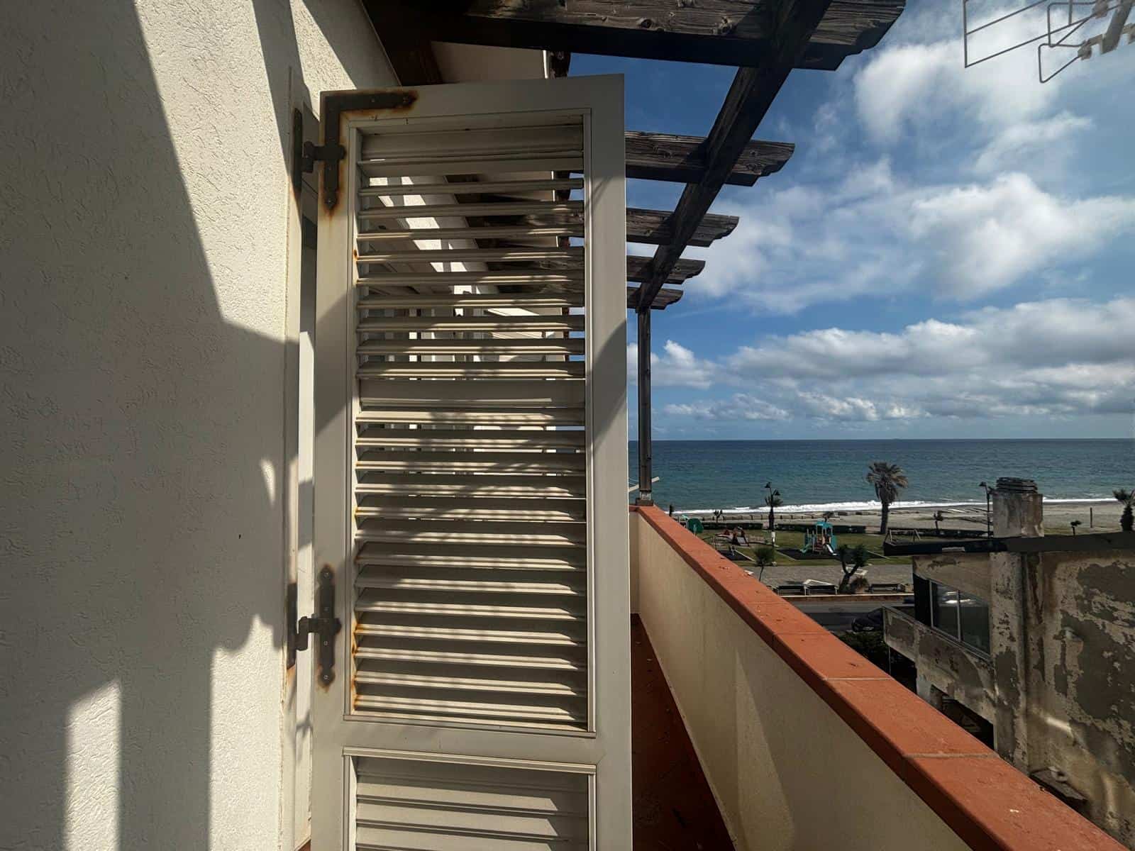 ALETTA VENTILATALE SU BALCONE CON VISTA MARE, in stile mediterraneo, con vista panoramica sulla spiaggia e il mare, ideale per case vacanza e immobili in affitto a NextCasa.