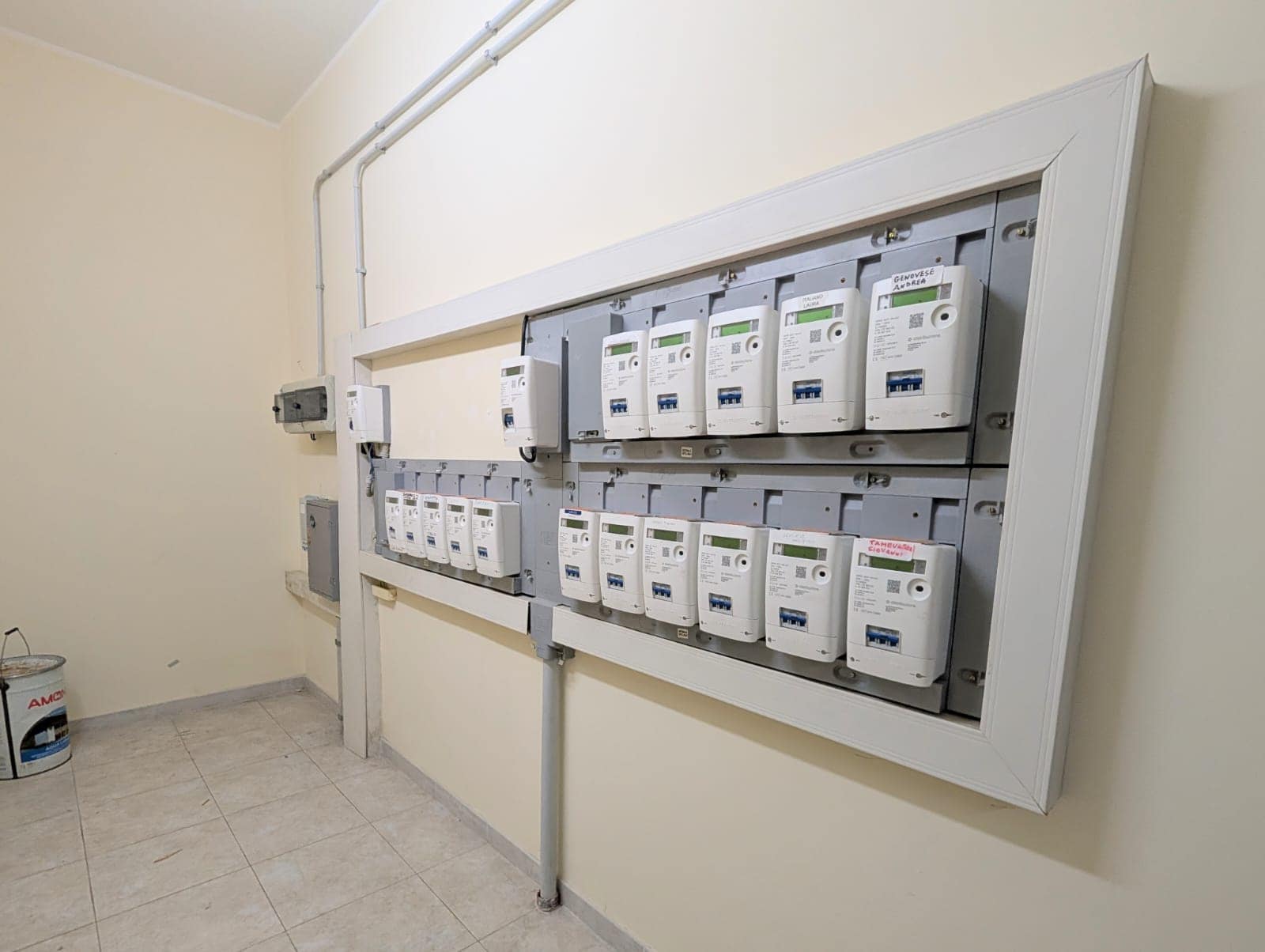 Impianto di contatori elettrici installato su parete in ambiente interno, con quadro elettrico e cablaggi visibili, rappresenta un sistema di distribuzione energetica domestica o industriale.