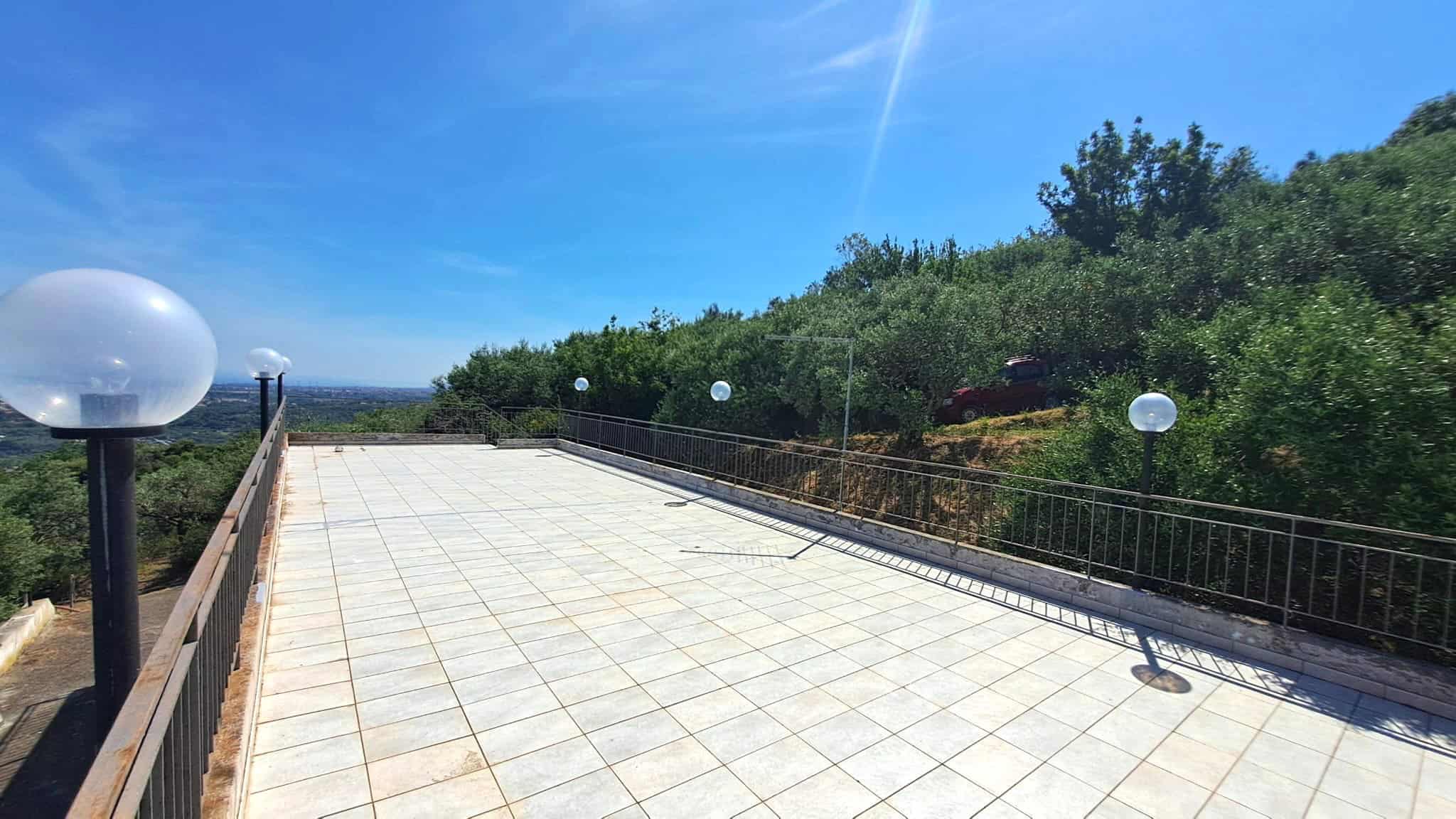 Ampia terrazza panoramica con vista sulla natura e il cielo azzurro, ideale per relax e socializzazione all'aperto.