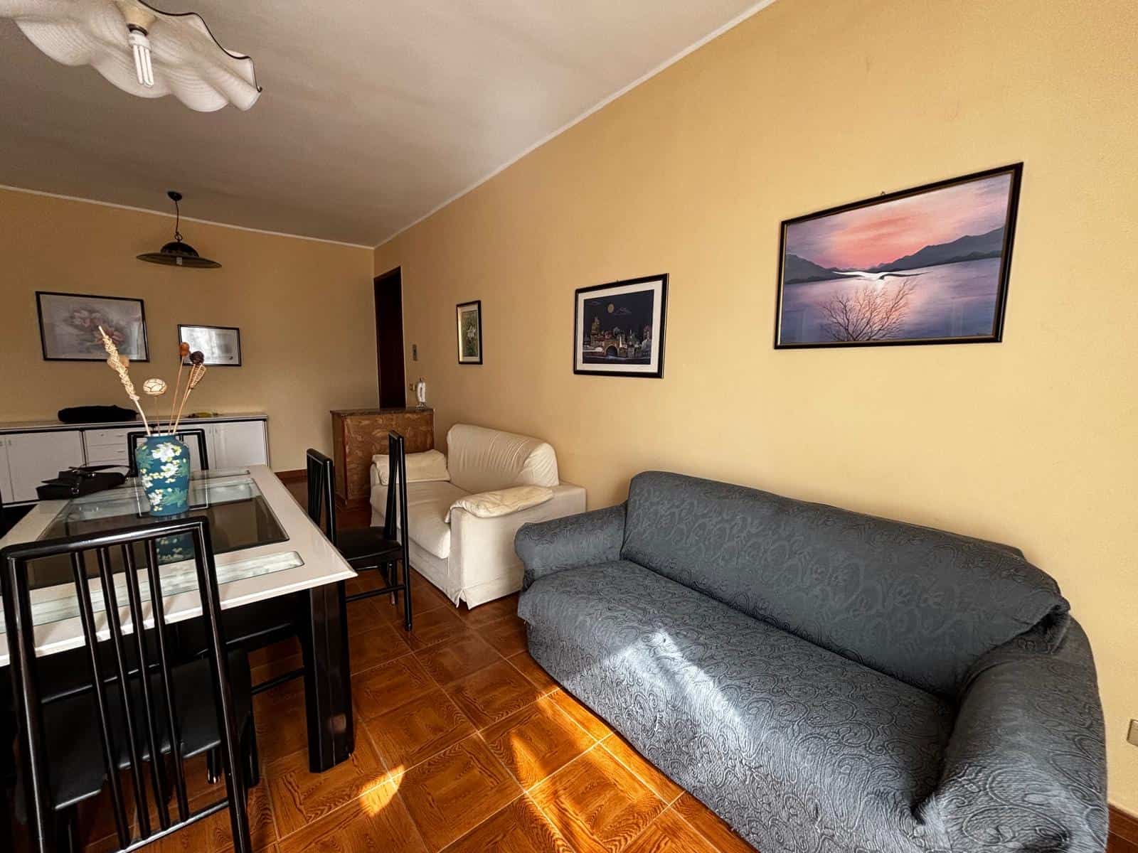 Ampia zona soggiorno con divani e sala da pranzo, arredamento moderno e accogliente, pareti decorate con quadri e fotografie, pavimento in legno, ambiente luminoso e confortevole, ideale per vivere mo.