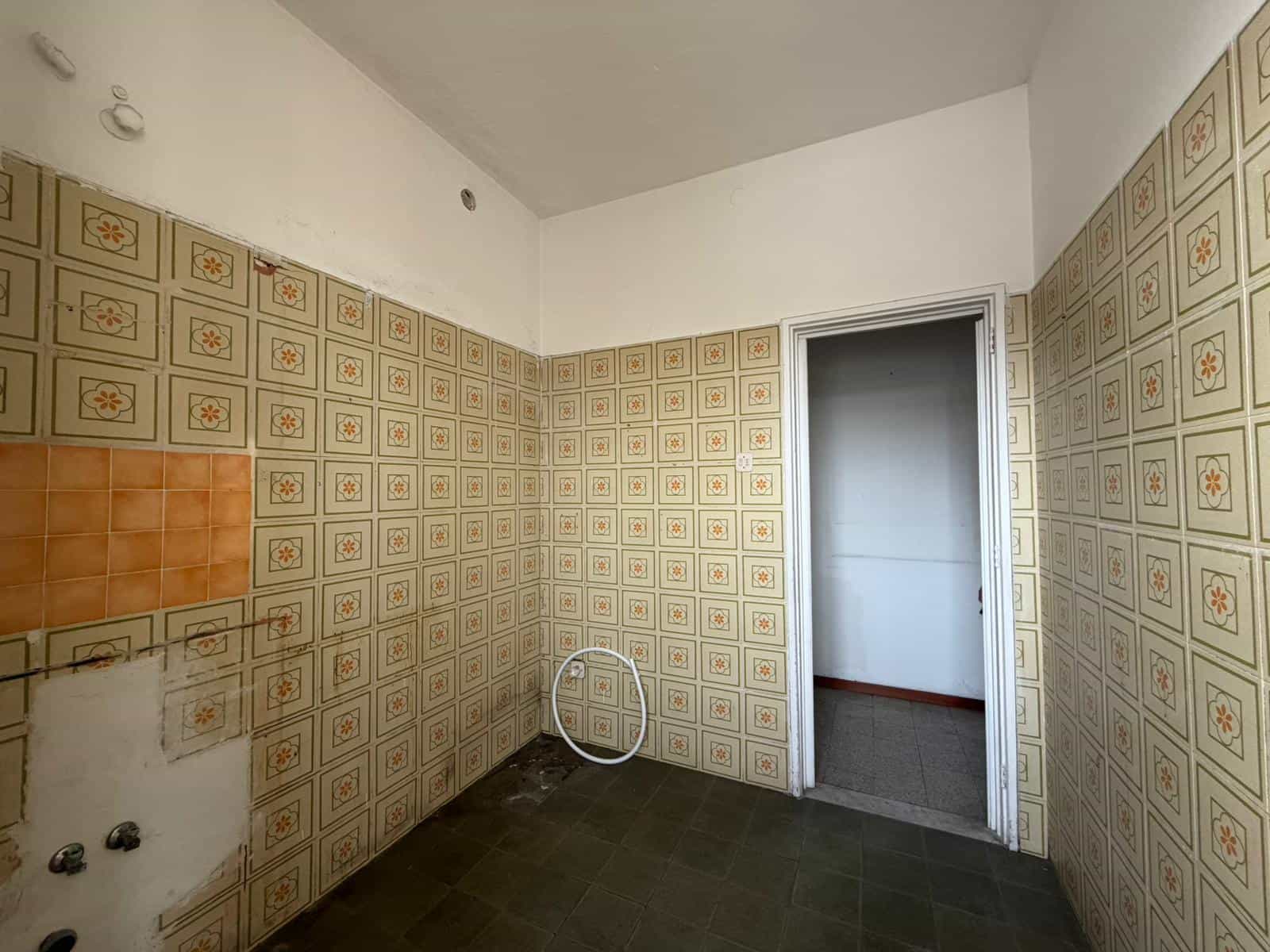 Piastrelle da cucina vintage con motivi geometrici in tonalità beige e arancione, pareti rivestite in stile retrò, spazio ideale per rinnovare la tua casa.