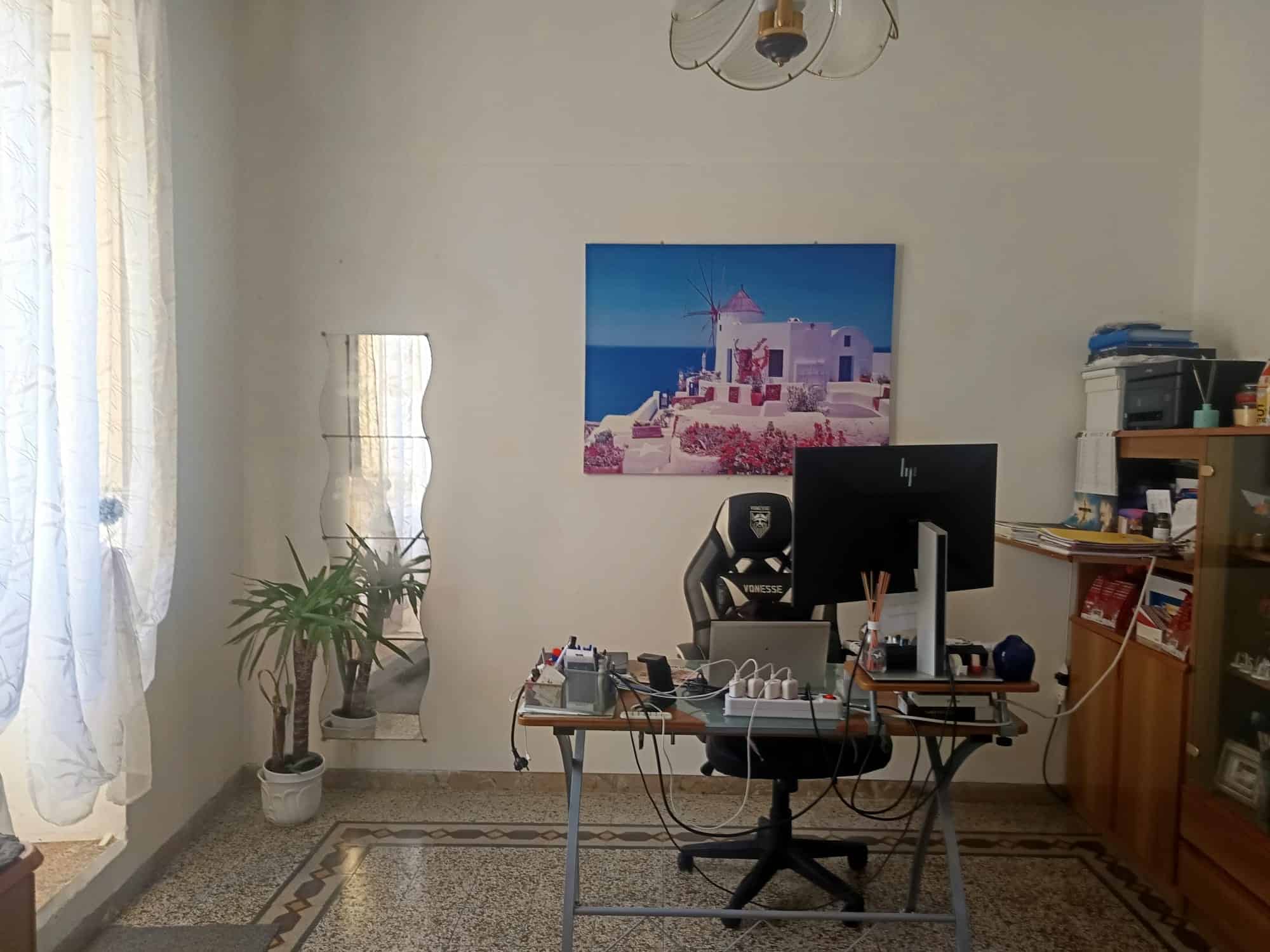 Sedie da ufficio ergonomiche e scrivania con computer e accessori in uno studio domestico luminoso e ben organizzato.