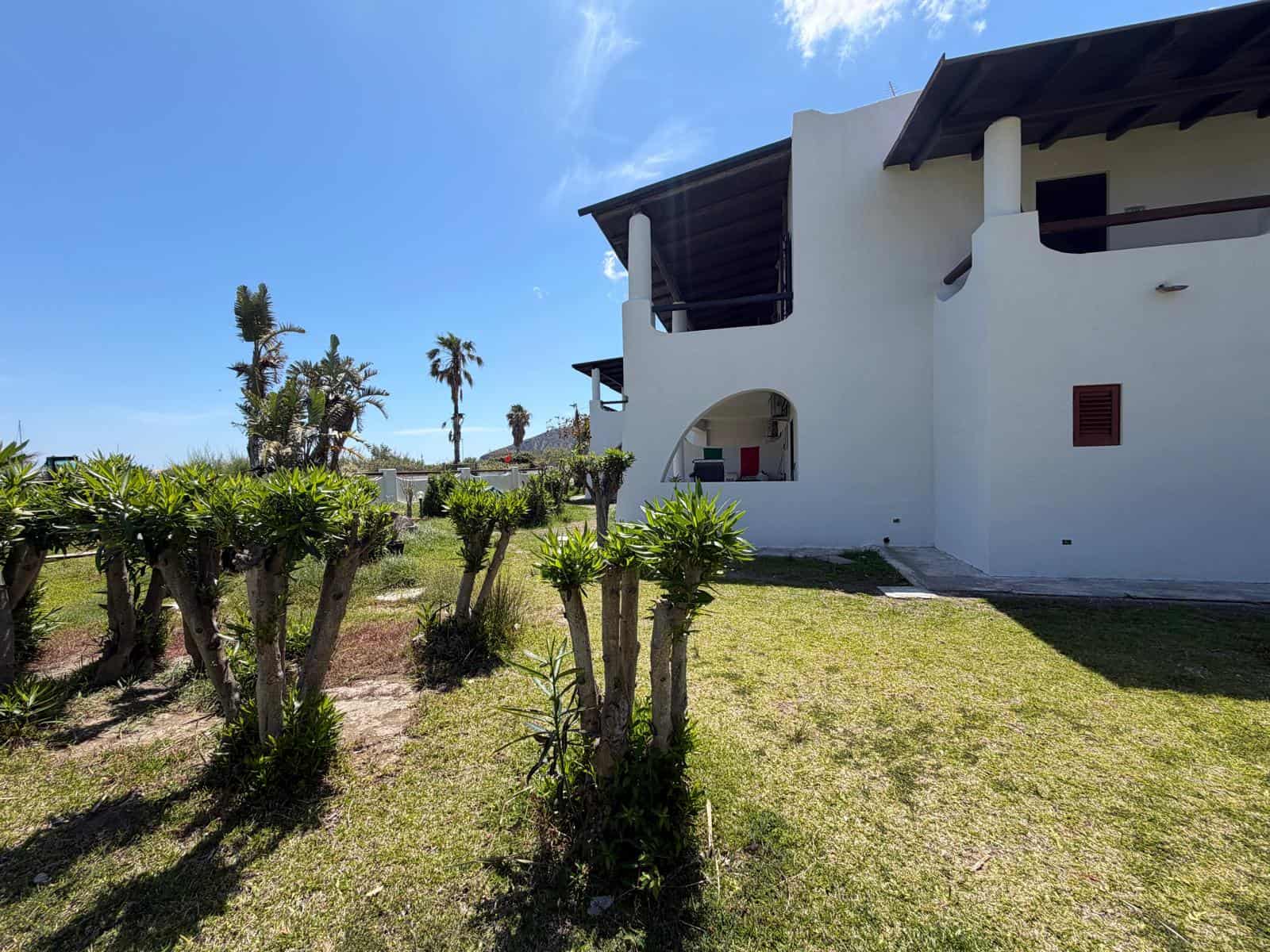Ampia casa moderna con terrazza e giardino ben curato, ideale per vacanze al mare in Italia, con vista panoramica e spazio esterno per relax e convivialità.