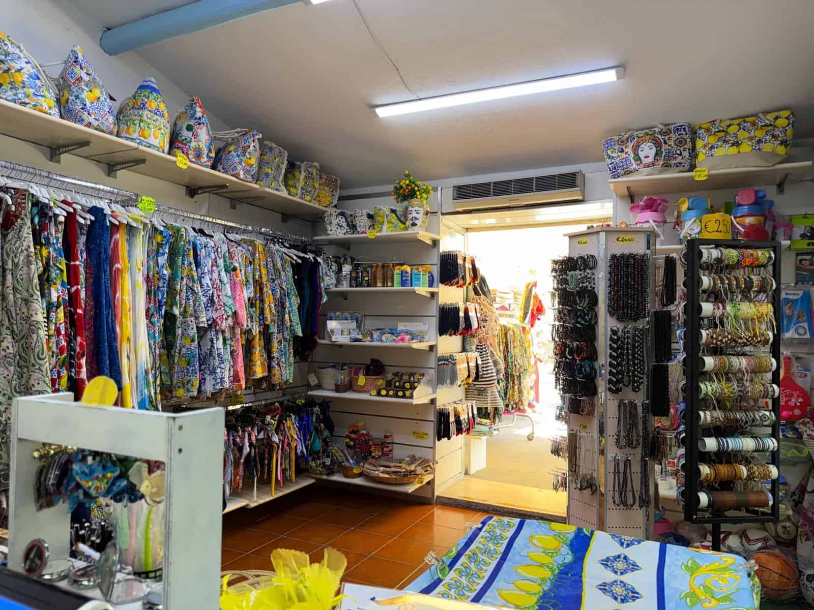 Negozio di articoli per la casa e decorazioni con tessuti colorati e accessori vari, vista dall’interno.