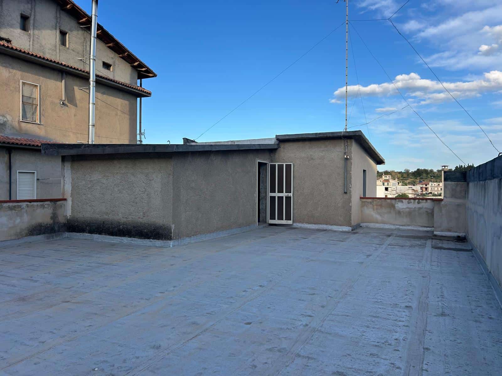 Ampia terrazza panoramica con vista urbana, superficie pavimentata e spazio aperto ideale per relax e attività all'aperto, situata sul tetto di un edificio residenziale.