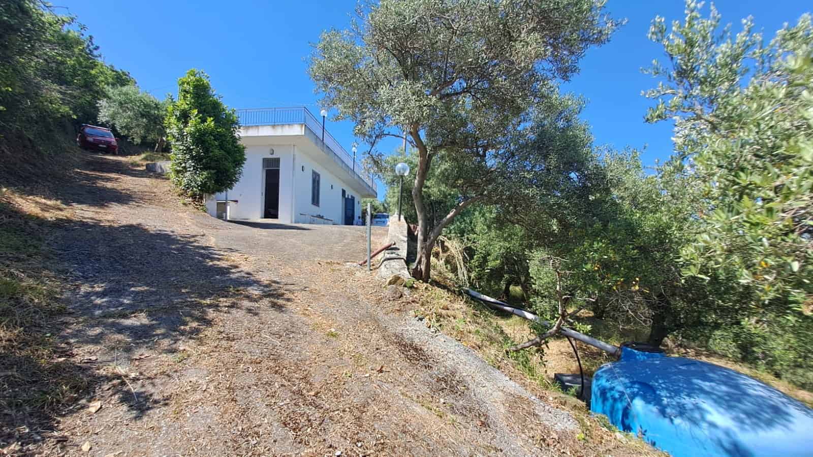 Ampia casa moderna su collina con terrazza e vista panoramica, circondata da alberi e natura, ideale per residenza o investimento immobiliare in zona tranquilla.